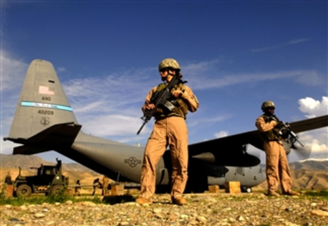 U.S. Air Force Airman 1st Class Kelliea Guthrie (left) and Senior Airman Greg Ellis provide security for a C-130 Hercules aircraft during a cargo mission at Feyzabab Airfield in Afghanistan, April 23, 2008.  