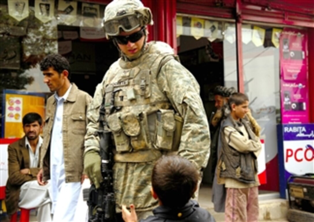U.S. Air Force Senior Airman Mark Ostrander talks to a young boy during a foot patrol in Charikar, Afghanistan, April 22, 2008. Ostrander is assigned to the police advisory team of the Charikar Provincial Reconstruction Team and is deployed from the 55th Security Forces Squadron, Offutt Air Force Base, Neb.
