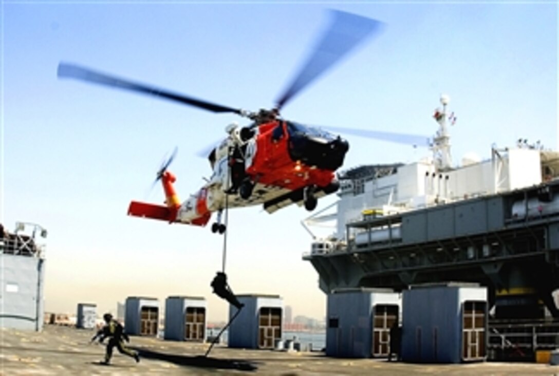 Members of the U.S. Coast Guard Marine Safety and Security Team move into position after 'fast roping' from a helicopter onto the deck of a ship during a training exercise in the Port of Long Beach, April 25, 2008. 