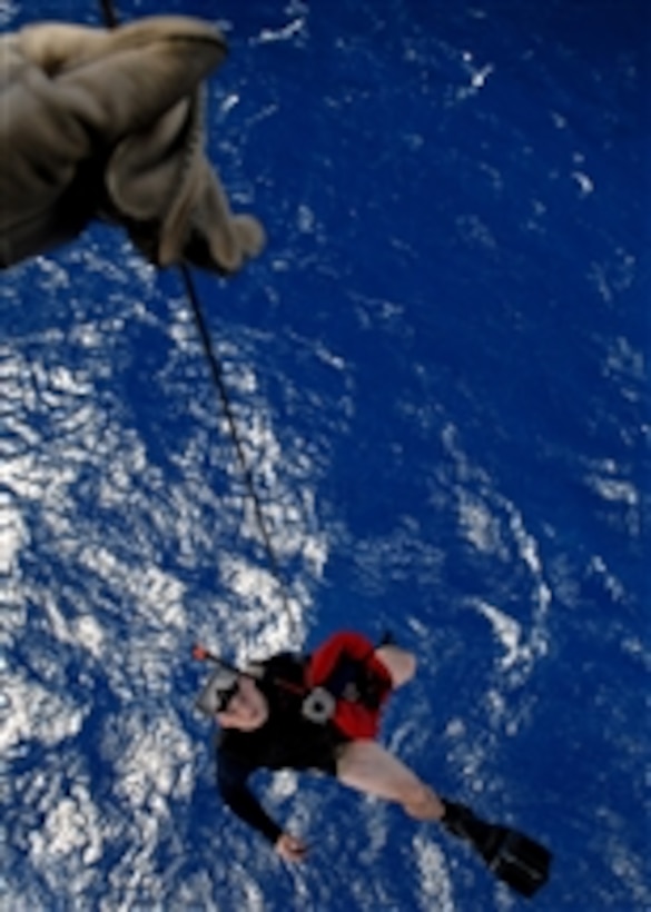 U.S. Navy Petty Officer 3rd Class Justin Sherman dangles over the Pacific Ocean as he is hoisted back into an SH-60B Seahawk helicopter on April 22, 2008.  Sherman is a Navy aviation warfare systems operator and a search and rescue swimmer assigned to Helicopter Antisubmarine Squadron Light 47 deployed onboard the aircraft carrier USS Abraham Lincoln (CVN 72).  