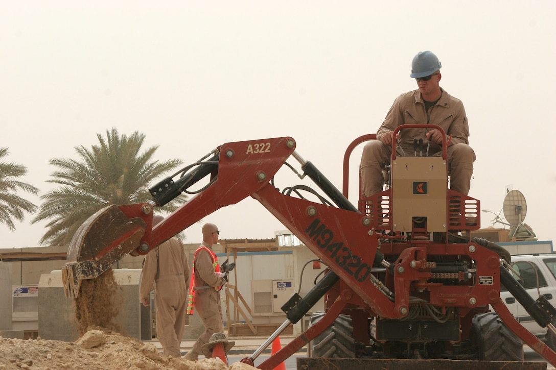 Cpl. Alan C. Hicks, a Marine with Marine Wing Communication Squadron 38, Marine Air Control Group 38, 3rd Marine Aircraft Wing (Forward), removes dirt from a location during a dig project here today. The Outside Plant Marines of MWCS-38 remove old Iraqi conduits from various locations on Al Asad Air Base and replace them with newer, more efficient ones.