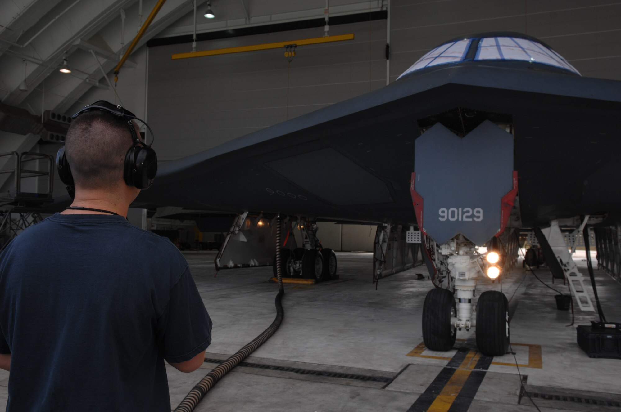 ANDERSEN AIR FORCE BASE, Guam -- Staff Sergeant Jonathan Sangricco communicates with the B-2 Spirit stealth bomber’s cockpit while they test head lights as part of routine pre-flight maintenance. Sergeant Sangricco is part of a maintenance team supporting the remaining B-2 Spirits at Andersen AFB. Keeping the B-2 Spirit bomber at a mission-ready status requires lots of hard work and a huge team effort by all maintainers working on the multi-role stealth bomber. The B-2s here have remained suspended pending the results from a safety investigation board following the first-ever crash of a stealth bomber Feb. 23 here, at Andersen AFB. The continuous bomber presence demonstrates U.S. commitment to promote security and stability in the Pacific region. Sergeant Sangricco is with the 36th Expeditionary Aircraft Maintenance Squadron and is deployed from the 509th Bomb Wing, Whiteman, AFB, Mo. (U.S. Air Force photo by Staff Sgt. Vanessa Valentine)


