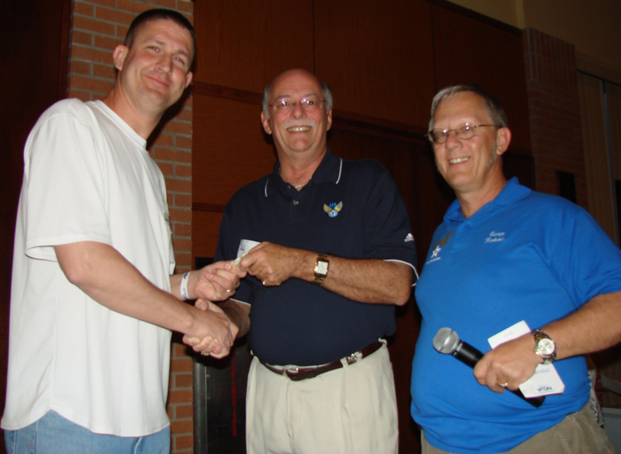 Master Sgt. James Moore, 71st Medical Group, receives a $1,001 cash prize from Air Force Association representatives Jay Jacobs and George Pankonin during the 41st Annual Enlisted Appreciation Night April 26 at the Vance Collocated Club. Enid community members provided a night of fun, food and prize giveaways for Team Vance enlisted members. (U.S. Air Force photo by Tech. Sgt. Mary Davis)