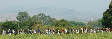 Joint Task Force-Bravo personnel hike through a field on their way to deliver food to a village near Humuya, Honduras, April 26 as part of the chapel hike program. About two and one half tons of staple food items were delivered to Honduran families in need. (U.S. Air Force photo by 1st Lt. Erika Yepsen)