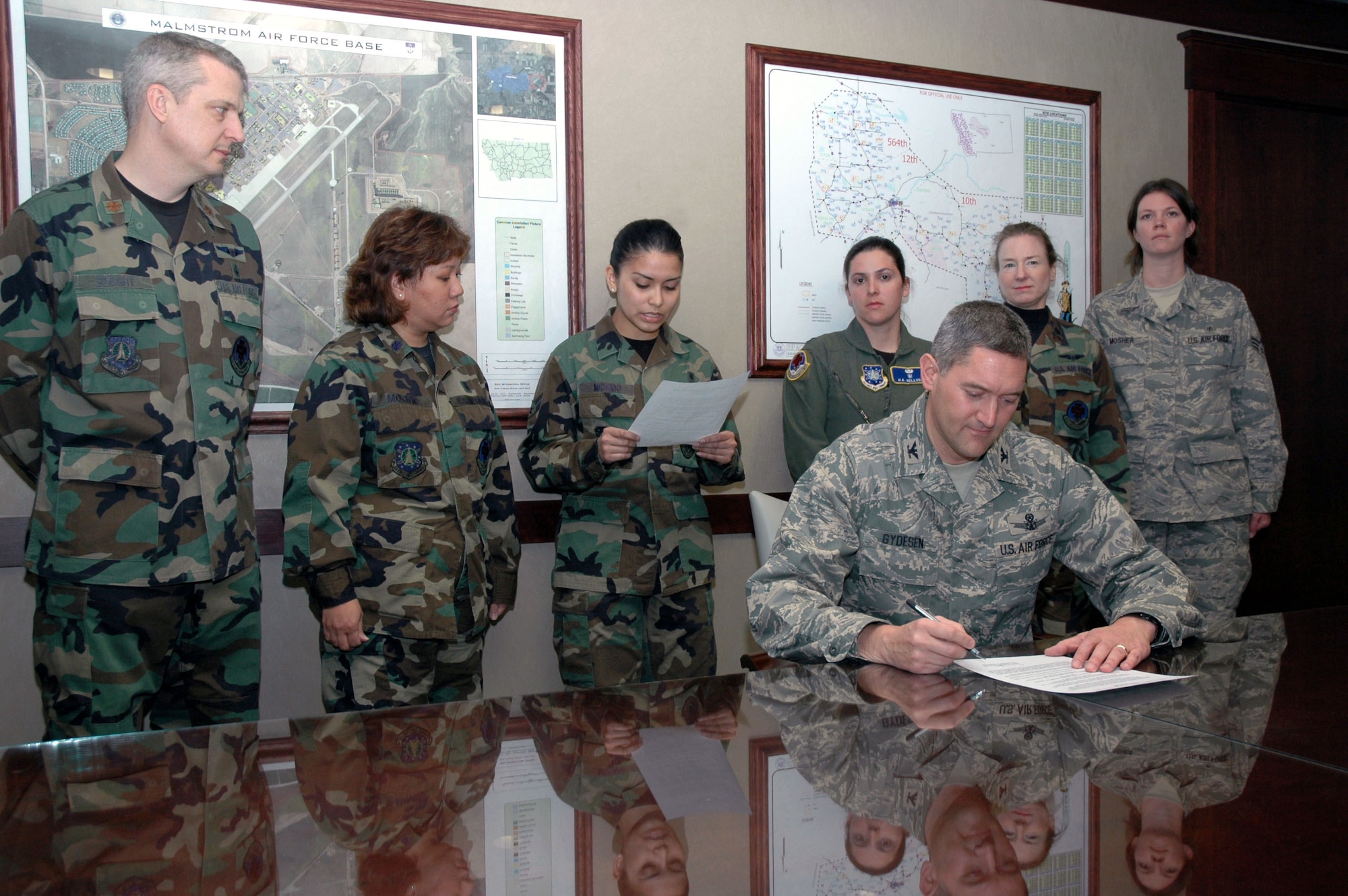 Col. Paul Gydesen, 341st Space Wing vice commander, signs a proclamation declaring May 5 to 9 Nurse and Technician Appreciation Week as Airman 1st Class Malaya Movido, 341st Medical Operations Squadron, medical technician, reads details of Nurse and Technician Appreciation Week to fellow 341st MDOS Airmen. (U.S. Air Force photo/Airman 1st Class Dillon White)