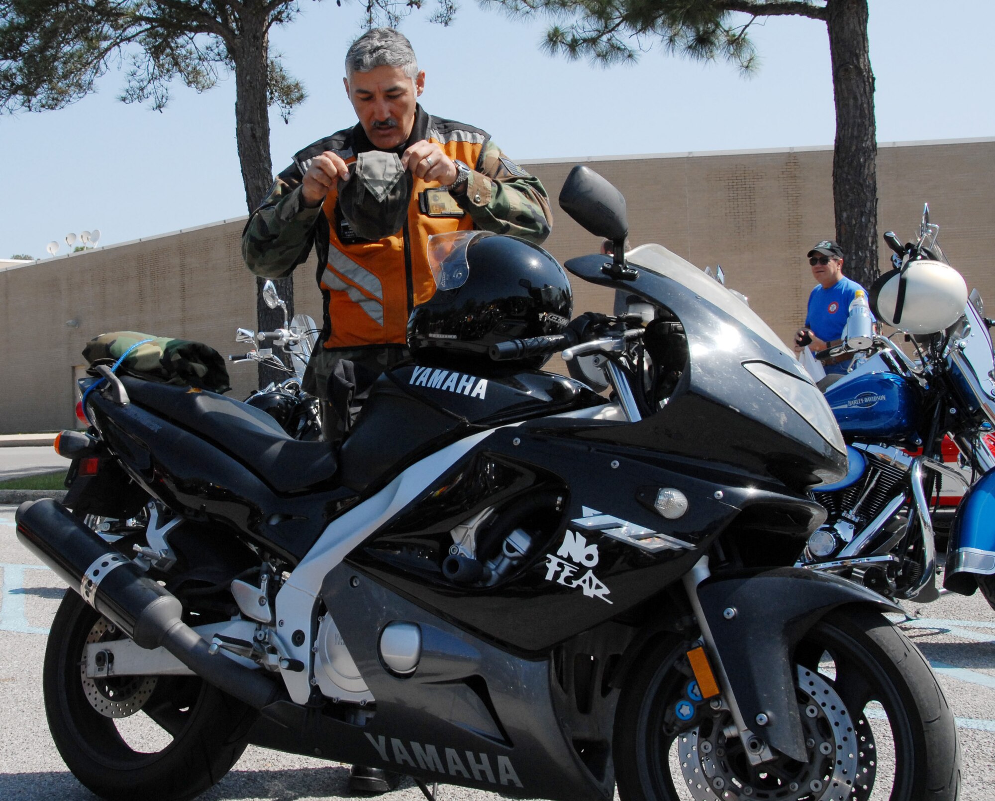 Tech Sgt. Stephen Guzman, 85th Test and Evaluation Squadron, puts on his safety gear after the Team Eglin Motorcycle Safety Day briefing April 29 at Eglin Air Force Base, Fla.  The second annual event brought out 150 riders to participate in a safety discussion, riding skills competition and group ride.  Photo by Staff Sgt. Samuel King Jr.