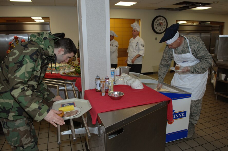 MINOT AIR FORCE BASE, N.D. — Col Joel Westa, 5th Bomb Wing commander, scoops ice cream for Airman 1st Class Matthew Mastrangelo, 5th Munitions Squadron. Colonel Westa, along with group commanders, first sergeants and chiefs, volunteered to serve the Airmen dinner at the Dakota Inn Dining Facility April 24 to show their appreciation for the service and dedication of junior Airmen. (U.S. Air Force photo by Senior Airman Cassandra Jones)