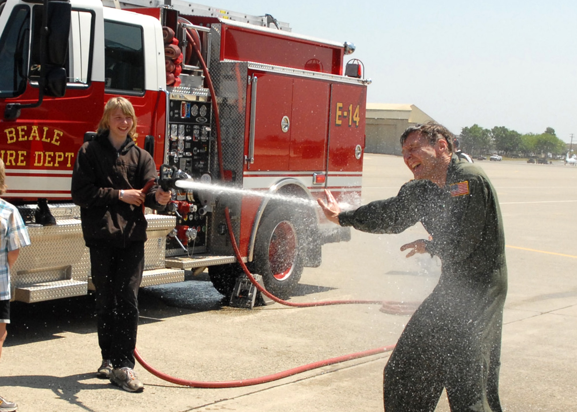 BEALE AIR FORCE BASE, CALIF. -- Nick Reif gives his dad the traditional "fini" flight water dousing here Apr. 25, 2008, while younger brother Brad waits his turn. Dad is Air Force Reservist Col. Al Reif, 940th Air Refueling Wing commander. The jet he flew, one of the final two KC-135R Stratotankers assigned to the wing, is scheduled to leave May 3, 2008, at 9:40 a.m., for the 916th ARW, Seymour Johnson AFB, N.C. The Beale Reservists will form a classic associate unit, partnering with the active duty Airmen for the RQ-4 Global Hawk unmanned surveillance and reconnaissance aircraft, as well as other support missions. (U.S. Air Force photo/Master Sgt. Ellen L. Hatfield)