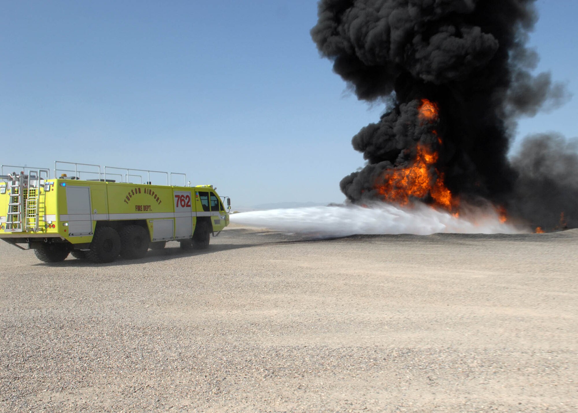 Tucson Airport Fire Department puts out a fire at the training pit during their annual training here at D-M on April 24.  355th Civil Engineer Squadron, firefighters help train about 16 TIA firefighters within a two day period so that TIA can make there Federal Aviation Administration requirements for the year.   (US Air Force Photo By:  Senior Airman Jacqueline Hawkins)
