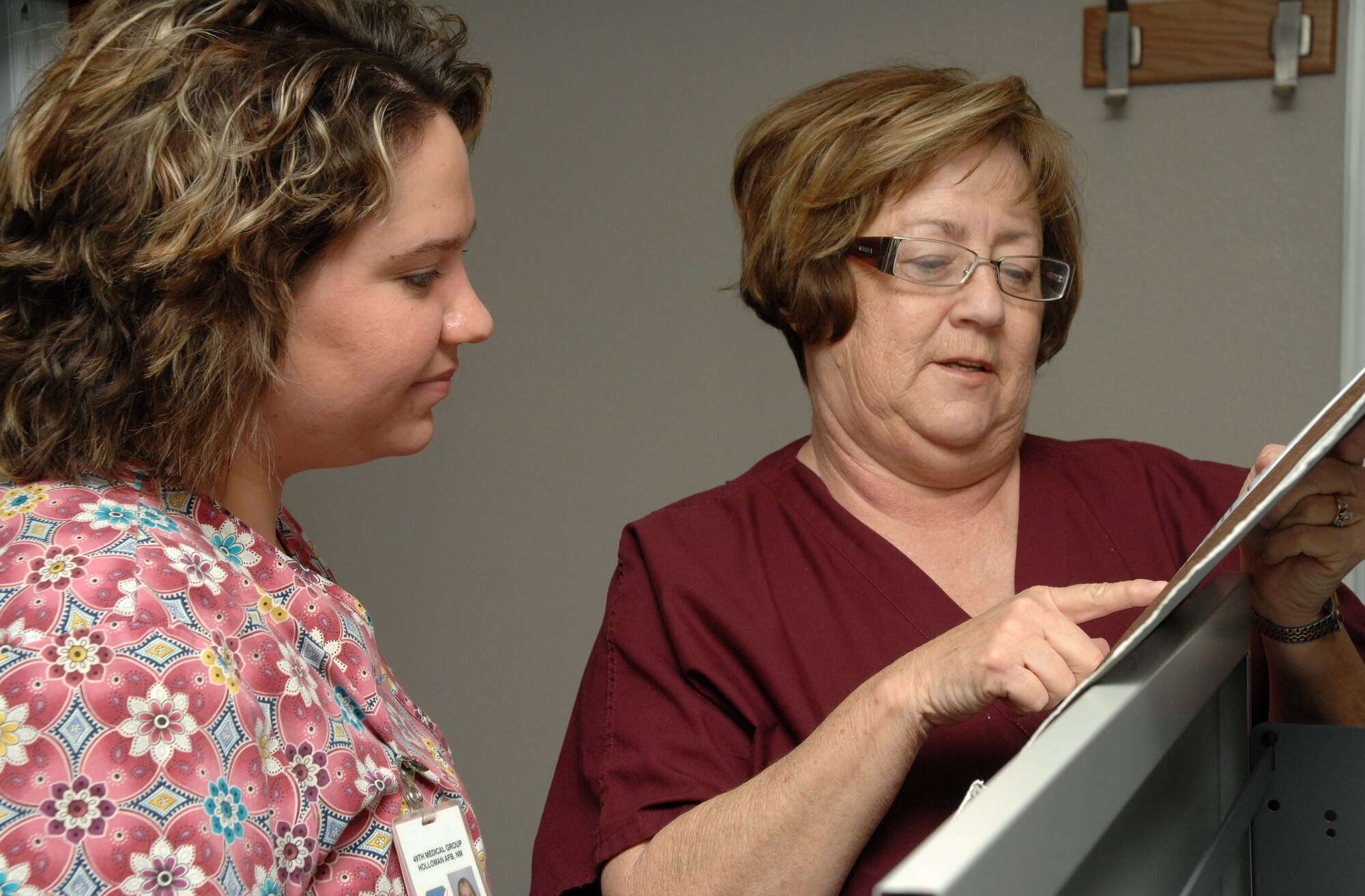 Christy Ziriak and Gwen McCourt, both nurses at the  Clinic here, discuss medical records. They are among the many nurses being recognized during National Nurse's Week here. (USAF photo by A1C Tiffany Trojca)