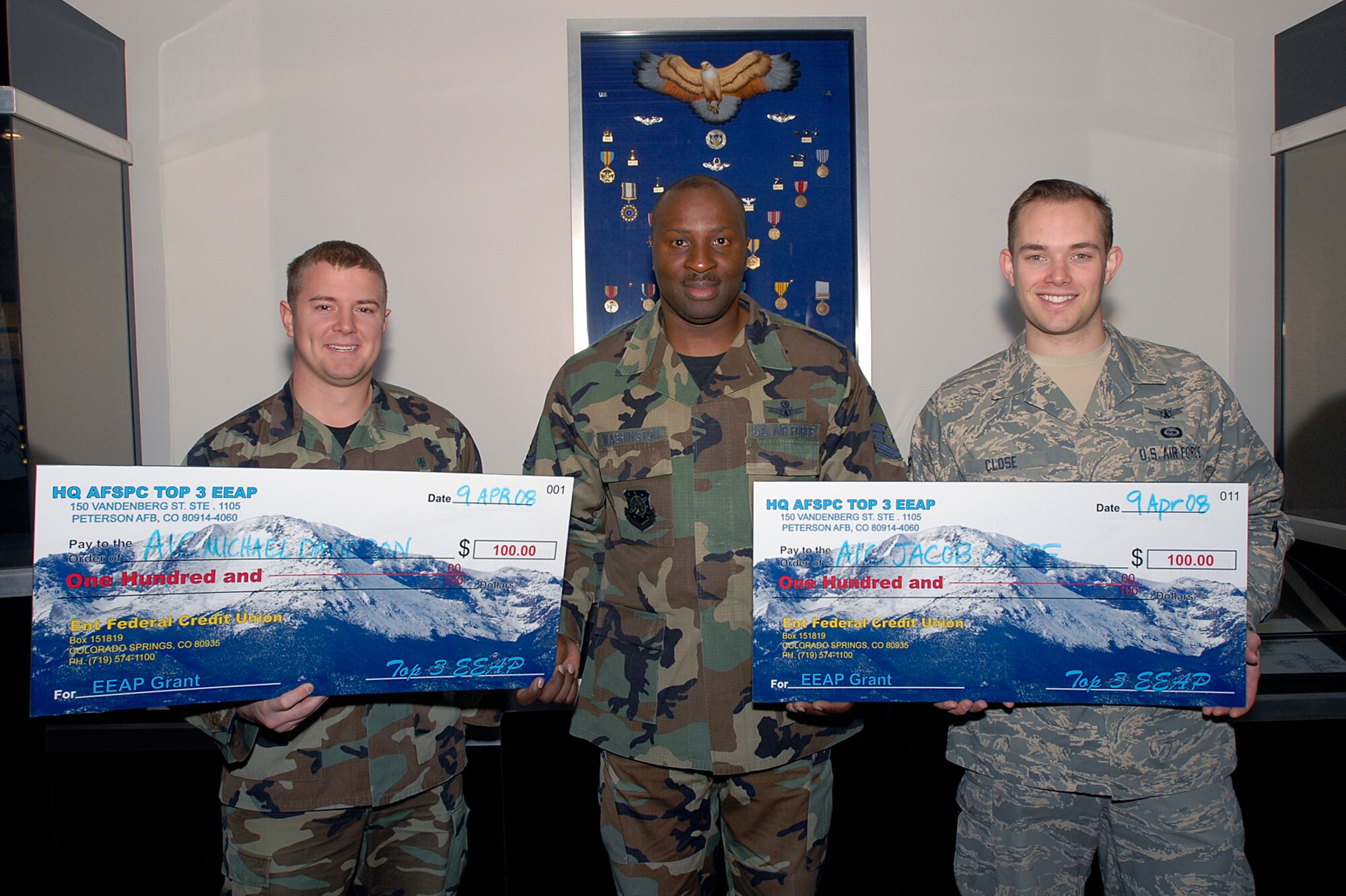 The Space Top 3 Association vice president, Master Sgt. Gary Washington, delivers $100 grants from the Enlisted Education Assistance Program recently at Headquarters Air Force Space Command at Peterson Air Force Base, Colo. Recipients were Senior Airman Michael Davidson (left), 21st Aeromedical Medical Squadron; Senior Airman Jacob Close, 21st Operations Support Squadron; and Senior Airman Brittany Hartkorn-Seligman, Air Warning Center, Cheyenne Mountain Air Force Station (not pictured). The Space Top 3 Association's goal is to donate educational grants quarterly. (Courtesy photo) 