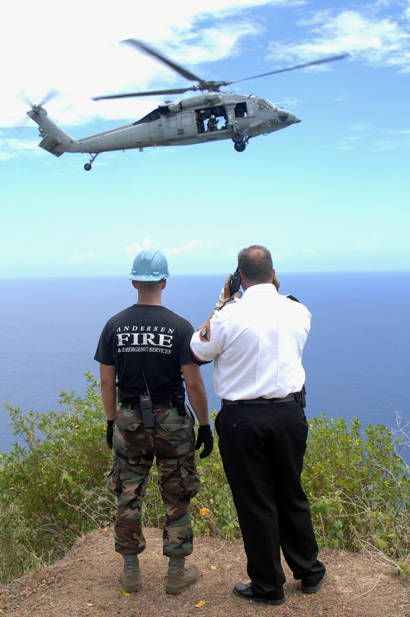 Airman 1st Class Jarold Burris and Dallas More, 36th Civil Engineer Squadron, await the arrival of Helicopter Sea Combat 25 members for an emergency airlift rescue at Tarague Beach for one of four simulated injured hikers April 28.  (U.S. Air Force Photo/Senior Airman Sonya Croston)