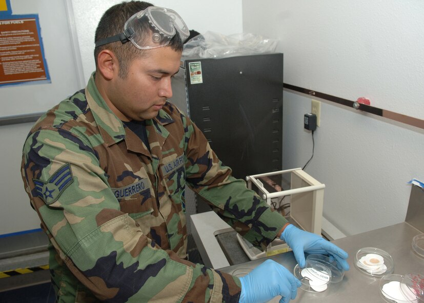 DYESS AIR FORCE BASE, Texas -- Senior Airman Rogelio Guerrero takes a filter pad from a heated glass dish April 24. The pad will go into a filter where fuel will be poured through it, determining the amount of sediment in the fuel. (U.S. Air Force Photo by Airman 1st Class Micheal Breaux)