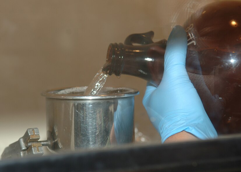DYESS AIR FORCE BASE, Texas -- Senior Airman Rogelio Guerrero pours one gallon of JP-8 jet fuel into a filter April 24. The fuel is poured from the bottle into the filter, where the fuel is forced through a thin piece of paper which collects the sediment in the fuel. (U.S. Air Force Photo by Airman 1st Class Micheal Breaux)