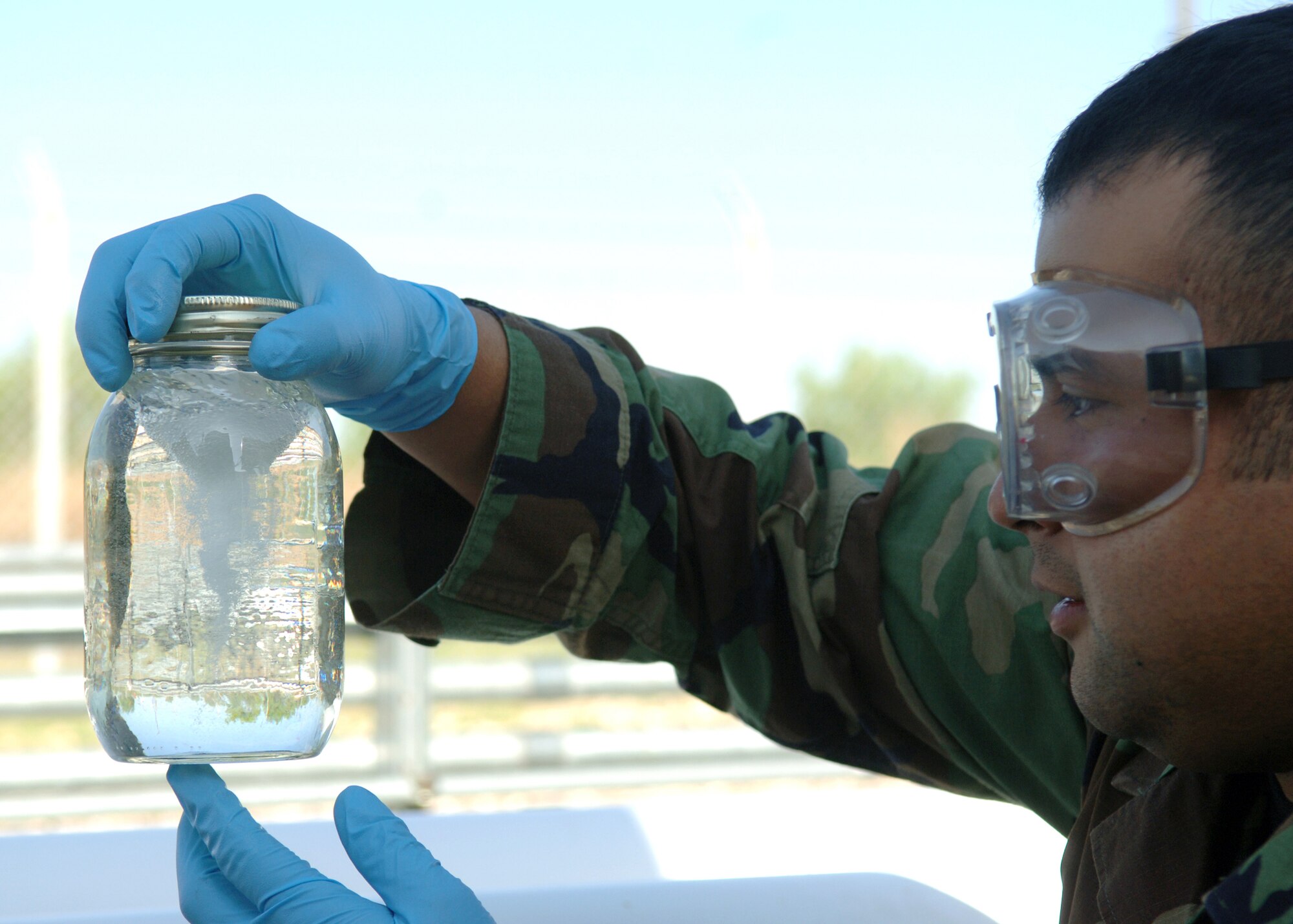 DYESS AIR FORCE BASE, Texas -- Senior Airman Rogelio Guerrero examines a jar of JP-8 fuel April 24. The fuel will later be tested to examine the flash point of the fuel, the amount of water in it, and the amount of impurities. (U.S. Air Force Photo by Airman 1st Class Micheal Breaux)