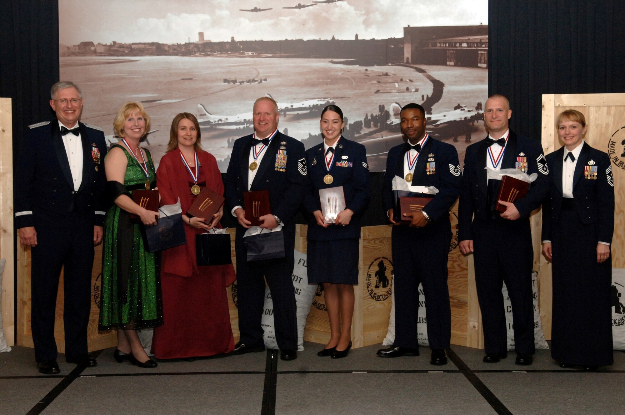 U.S. Air Forces in Europe Commander Gen. Roger Brady, left, and USAFE Command Chief Master Sergeant Pamela Derrow, right, stand with the USAFE 2007 Outstanding Airmen of the Year. They are (left to right) Category 2 Civilian of the Year: Mrs Barbra Langmaid, 65th Air Base Wing, Lajes Field, Azores Category 1 Civilian of the Year: Mrs Jeananne Creager, 48th Mission Support Group, RAF Lakenheath, United Kingdom;  First Sergeant of the Year: Master Sgt. Kevin Drake, 48th Aircraft Maintenance Squadron, RAF Lakenheath, United Kingdom; Airman of the Year – Senior Airman Alicia Goetschel, 100th Security Forces Squadron, RAF Mildenhall, United Kingdom; Noncommissioned Officer of the Year: Tech Sgt. Larnell Smith, 3rd Air Force A4 Directorate, Ramstein Air Base, Germany; Senior NCO of the Year: Senior Master Sgt. Timothy McLaughlin, USAFE A7 Directorate, Ramstein AB, Germany; Not pictured is the Company Grade Officer of the Year: Capt Ryan Crowley, 100th Civil Engineer Squadron, RAF Mildenhall, United Kingdom, who was unable to attend the banquet.