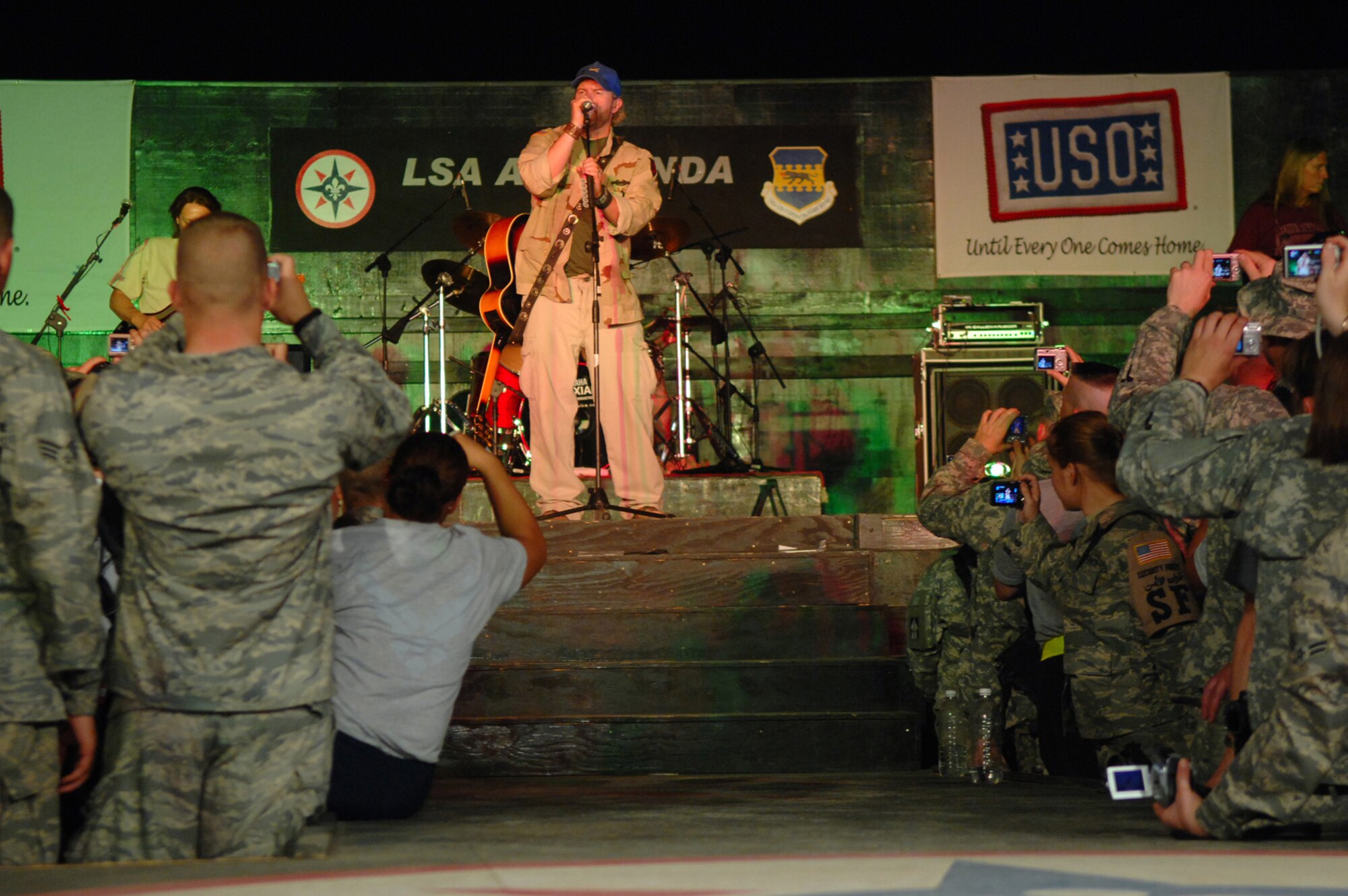 BALAD AIR BASE, Iraq -- Country music superstar Toby Keith sings to a crowd of more than 5,000 servicemembers here, April 28. Mr. Keith told those in attendance that he was proud of their service and thankful for their efforts in fighting terrorists and keeping America free. He referred to military members as 'warriors' and was present for the re-enlistments of five Soldiers stationed at Logistics Support Agency Anaconda, which is co-located with Balad. Mr. Keith is wrapping up his sixth USO tour in Iraq; his show at Balad marked his 117th show in the Area of Responsibility. (U.S. Air Force photo/ Senior Airman Julianne Showalter)