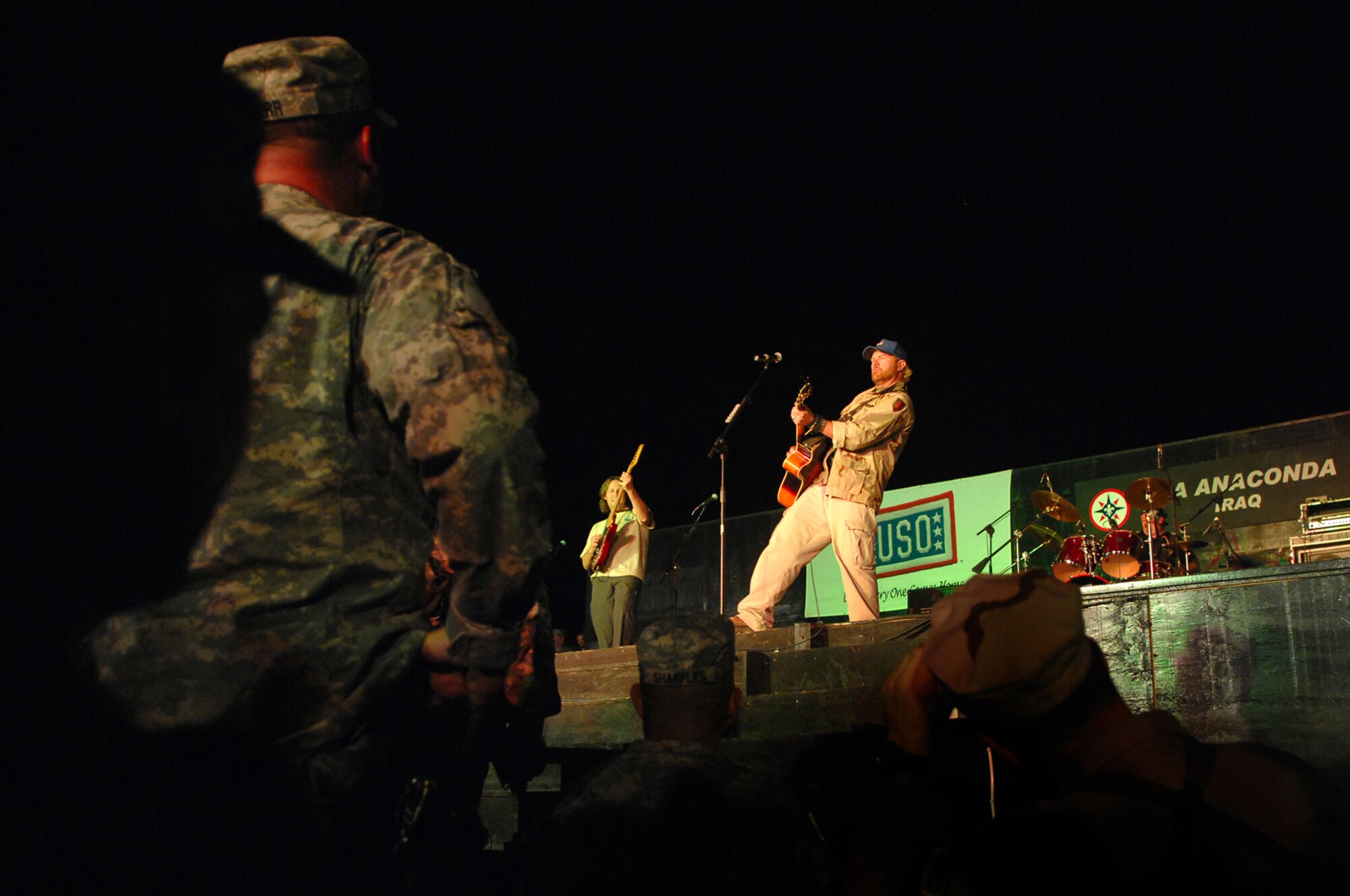 BALAD AIR BASE, Iraq -- Country music superstar Toby Keith sings to a crowd of more than 5,000 servicemembers here, April 28. Mr. Keith told those in attendance that he was proud of their service and thankful for their efforts in fighting terrorists and keeping America free. He referred to military members as "warriors" and was present for the re-enlistments of five Soldiers stationed at Logistics Support Agency Anaconda, which is co-located with Balad. Mr. Keith is wrapping up his sixth USO tour in Iraq; his show at Balad marked his 117th show in the Area of Responsibility. (U.S. Air Force photo/ Senior Airman Julianne Showalter)