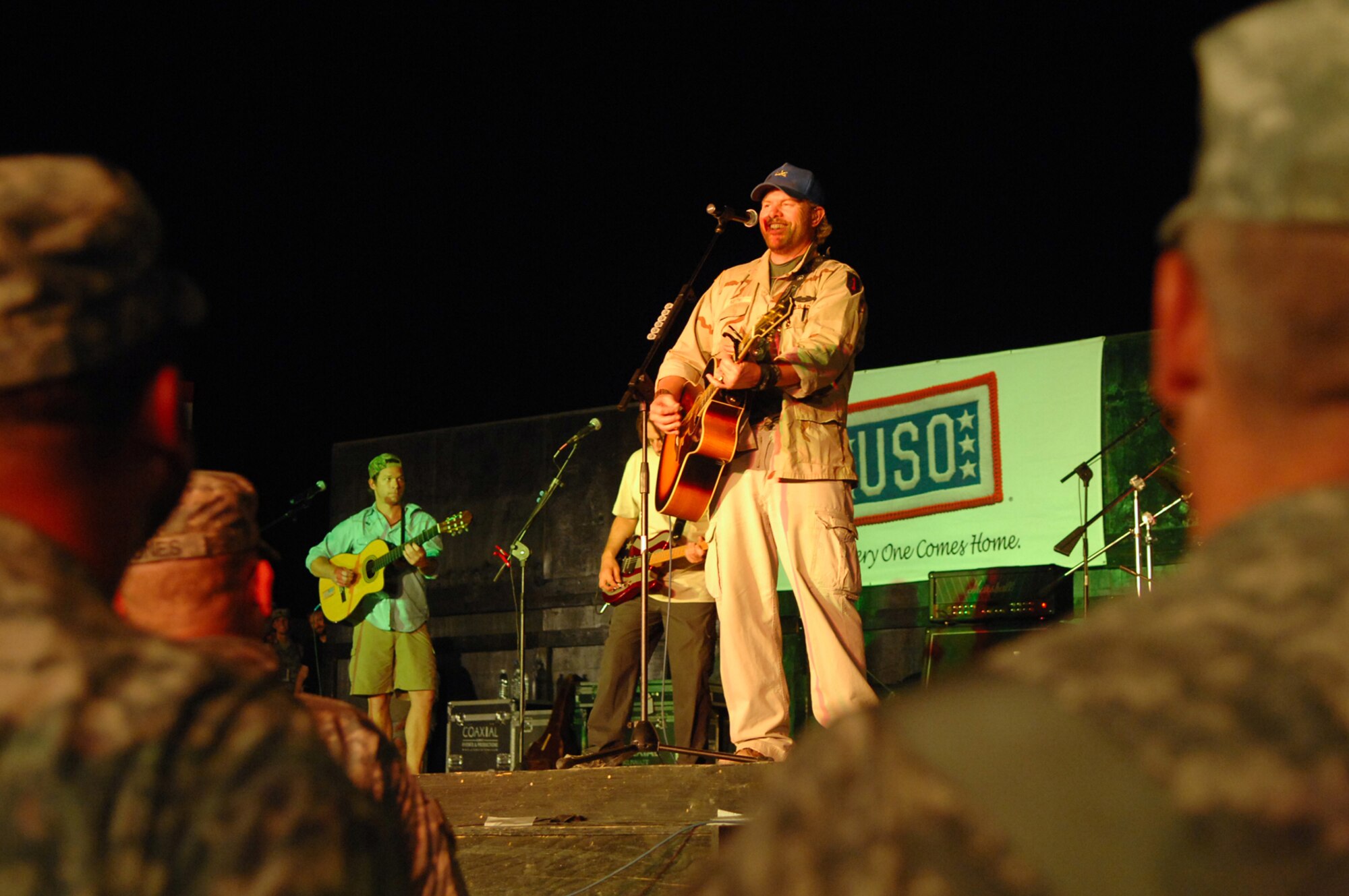BALAD AIR BASE, Iraq -- Country music superstar Toby Keith sings to a crowd of more than 5,000 servicemembers here, April 28. Mr. Keith told those in attendance that he was proud of their service and thankful for their efforts in fighting terrorists and keeping America free. He referred to military members as "warriors" and was present for the re-enlistments of five Soldiers stationed at Logistics Support Agency Anaconda, which is co-located with Balad. Mr. Keith is wrapping up his sixth USO tour in Iraq; his show at Balad marked his 117th show in the Area of Responsibility. (U.S. Air Force photo/ Senior Airman Julianne Showalter)