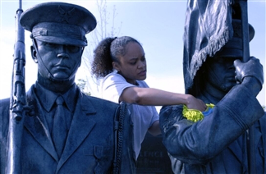 U.S. Air Force Tech. Sgt. Terisa Pennington scrubs a bronze honor guard statue during a work party, April 19, 2008, at the U.S. Air Force Memorial in Arlington, Va. More than 50 volunteers from The U.S. Air Force Sergeants Association gathered to help spruce up the site. 