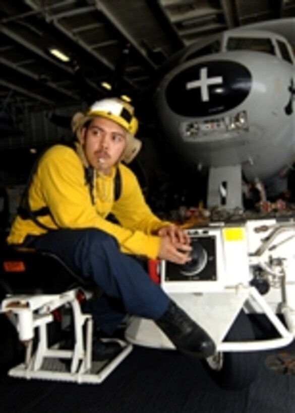 U.S. Navy Aviation Boatswain's Mate Airman Rich Ownbey watches closely for directions as he maneuvers an E-2C Hawkeye aircraft attached to Carrier Airborne Early Warning Squadron 116 across the hangar bay of the aircraft carrier USS Abraham Lincoln (CVN 72) while underway in the Indian Ocean on April 26, 2008.  