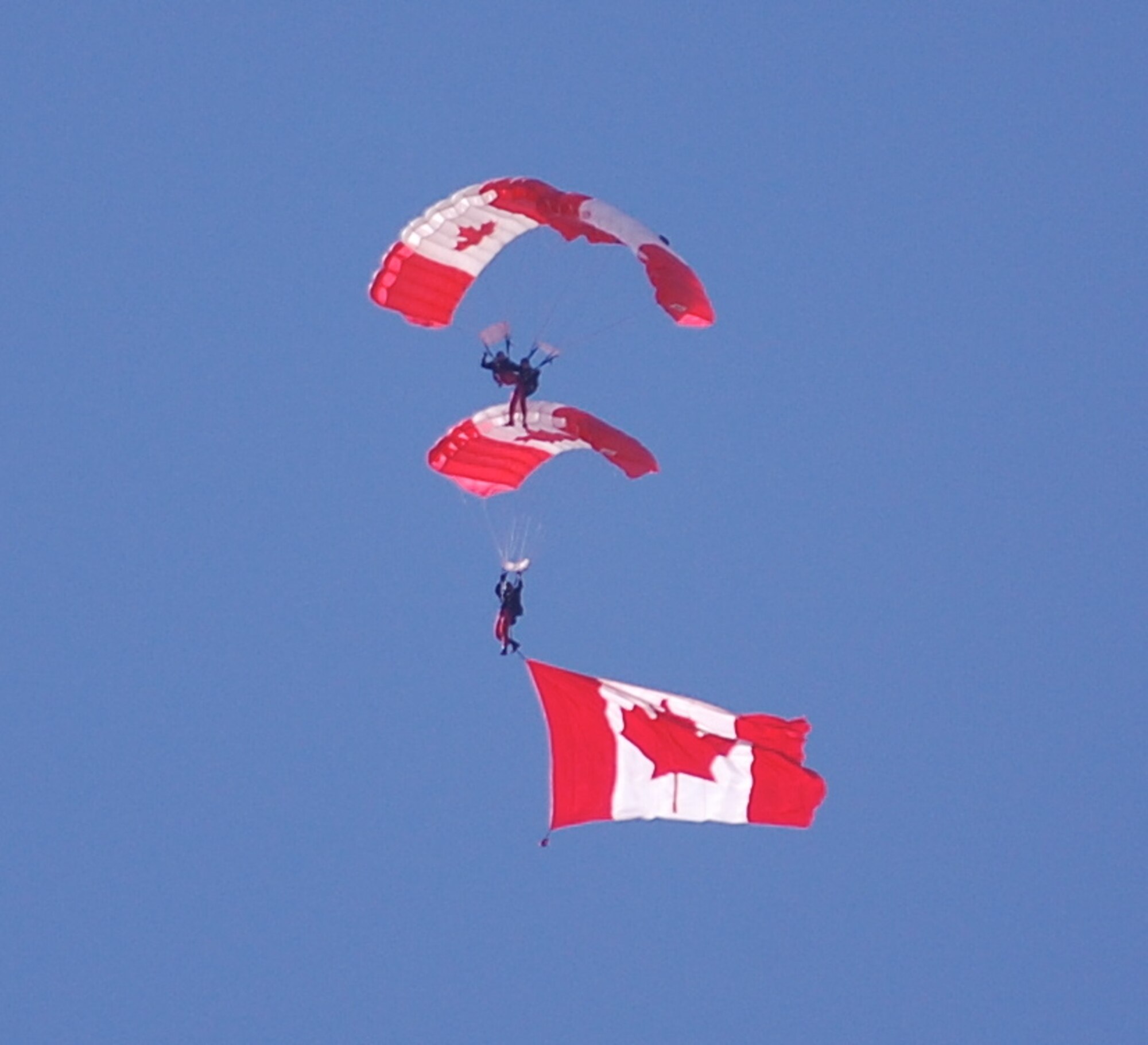 The SkyHawks are a sub-unit of the Canadian Forces Land Advanced Warfare Centre located in Trenton, Ontario. In the team’s 37-year history the Canadian Force Parachute Team – the SkyHawks – have performed around the world to an estimated 70 million spectators under our signature Canadian flag parachutes. This is their Canadian "T" formation.
