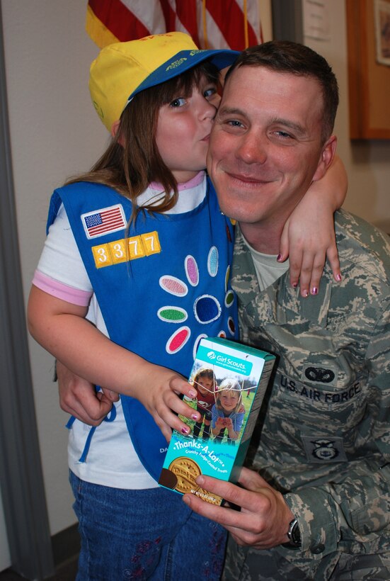 Staff Sgt. Michael Stinemetze, Jr., 301st Security Forces Squadron fire team member, gets a show of support from one of the Fort Worth Circle T Council's Daisy girl scouts from Troop 3377. Nearly a baker's dozen of Daisies, Brownies and Girl Scouts from this troop brought in cookies donated to 301st Fighter Wing troops stationed at the Naval Air Station Joint Reserve Base Carswell Field, Texas. There were over four cases donated. (U. S. Air Force Photo/Tech. Sgt. Stephen Bailey) 