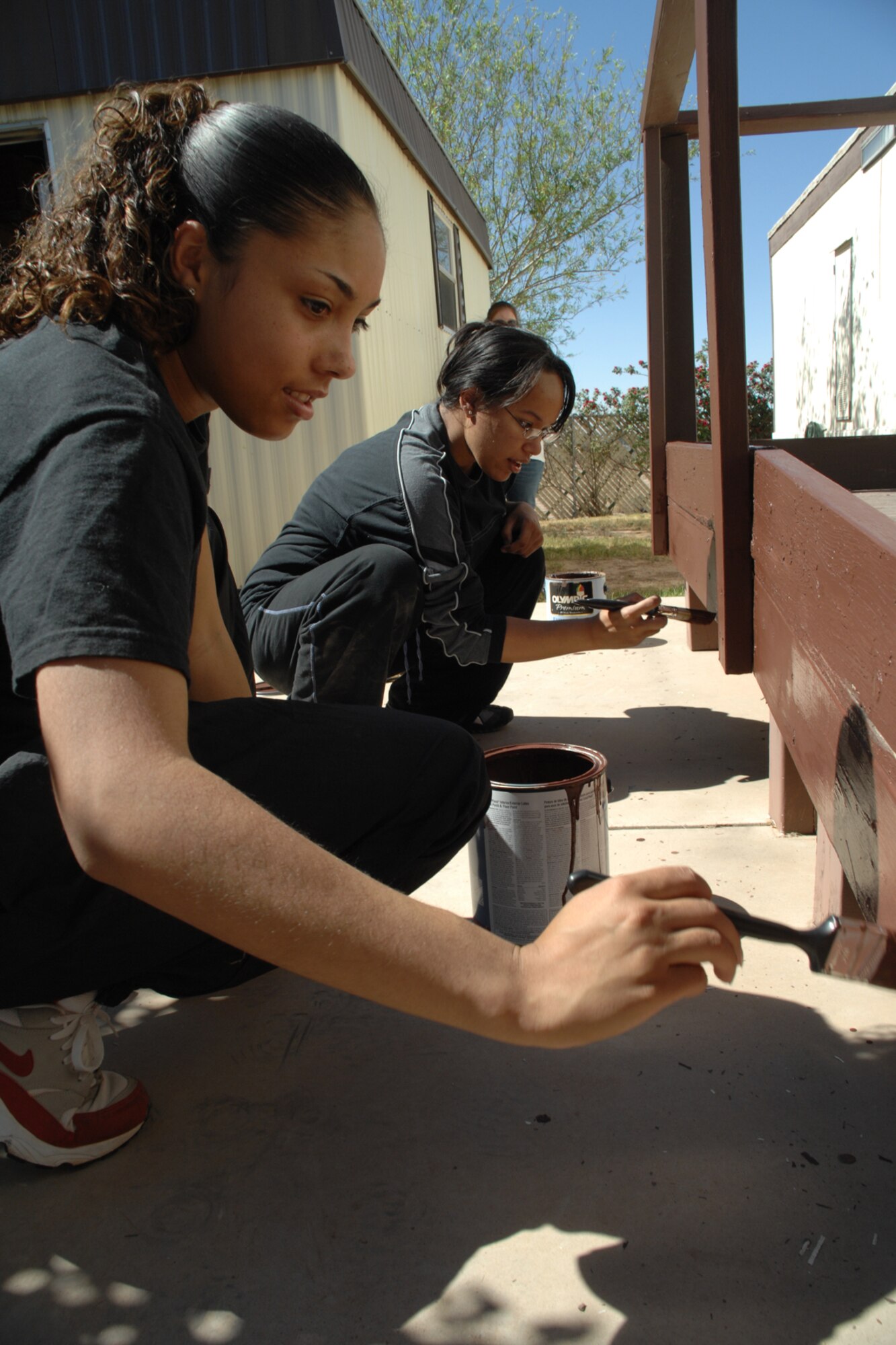 ALAMOGORDO, N.M.--Airman Basic Marissa Manaya and Staff Sgt. Octavia Garrett repaints the porch of a local citizen during the United Way of Otero County Day of Caring in Alamogordo, N.M. Both are part the 49th Maintenance Group. (U.S. Air Force photo/Airman 1st Class Jamal D. Sutter)