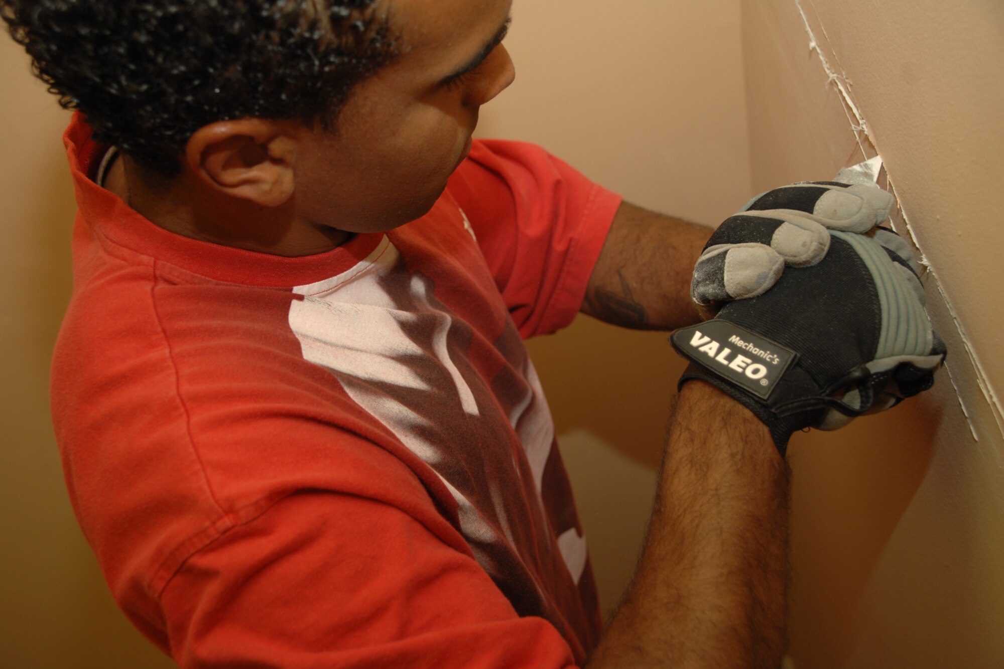 ALAMOGORDO, N.M.--Airman Antoine Moon, 49th Civil Engineer Squadron, works on dry wall during the United Way of Otero County Day of Caring in Alamogordo, N.M. Airman Moon, along with his team members, replaced the dry wall. (U.S. Air Force photo/Airman 1st Class Jamal D. Sutter)
