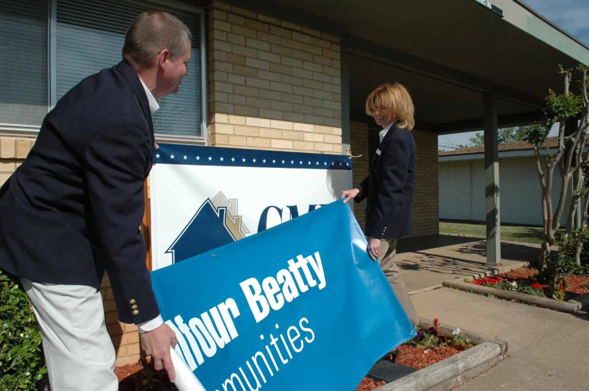 Patrick McVey, GMH lifeworks coordinator and Patti Osburn, GMH assistant community manager size up a new banner and new name [Balfour Beatty Communities] at the GMH Housing Office in the Vandenberg Hills housing area. “We're preparing for a name change,” said GMH Community Manager Cindy Murillo, we’re the same great people serving the same great Tinker Community.” Residents who attend the lease signing event may notice a name change on documents. GMH is being acquired by Balfour Beatty, engineering and construction firm.