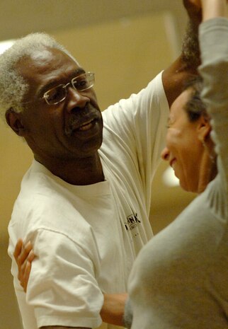 Calvin King turns Diana Saillant during salsa practice at the Fitness and Sports Center April 29.  King is the lead instructor of the class and Saillant is a student. (U.S. Air Force photo/Senior Airman Nicholas Pilch)