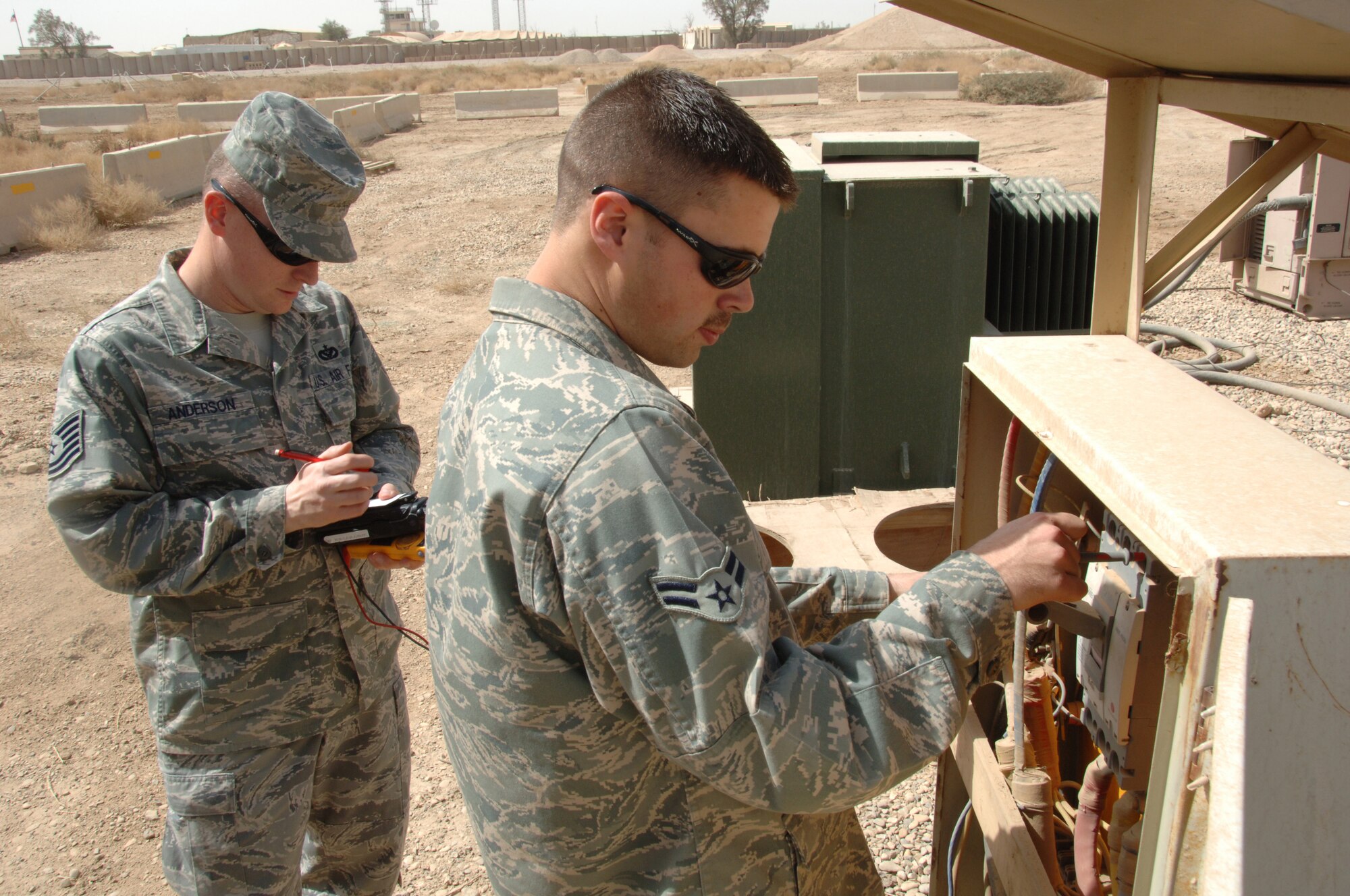 Tech. Sgt. Todd Anderson and Airman 1st Class Chris Dominick check voltage and amperage readings with a multi meter to examine power consumption for a building March 20.  Both are assigned to the 407th Air Expeditionary Group at Ali Base, Iraq. Sergeant Anderson is deployed from Eielson AFB, Alaska. Airman Dominick is deployed from Elmendorf AFB, Alaska. (U. S. Air Force photo/Tech. Sgt. Sabrina Johnson)