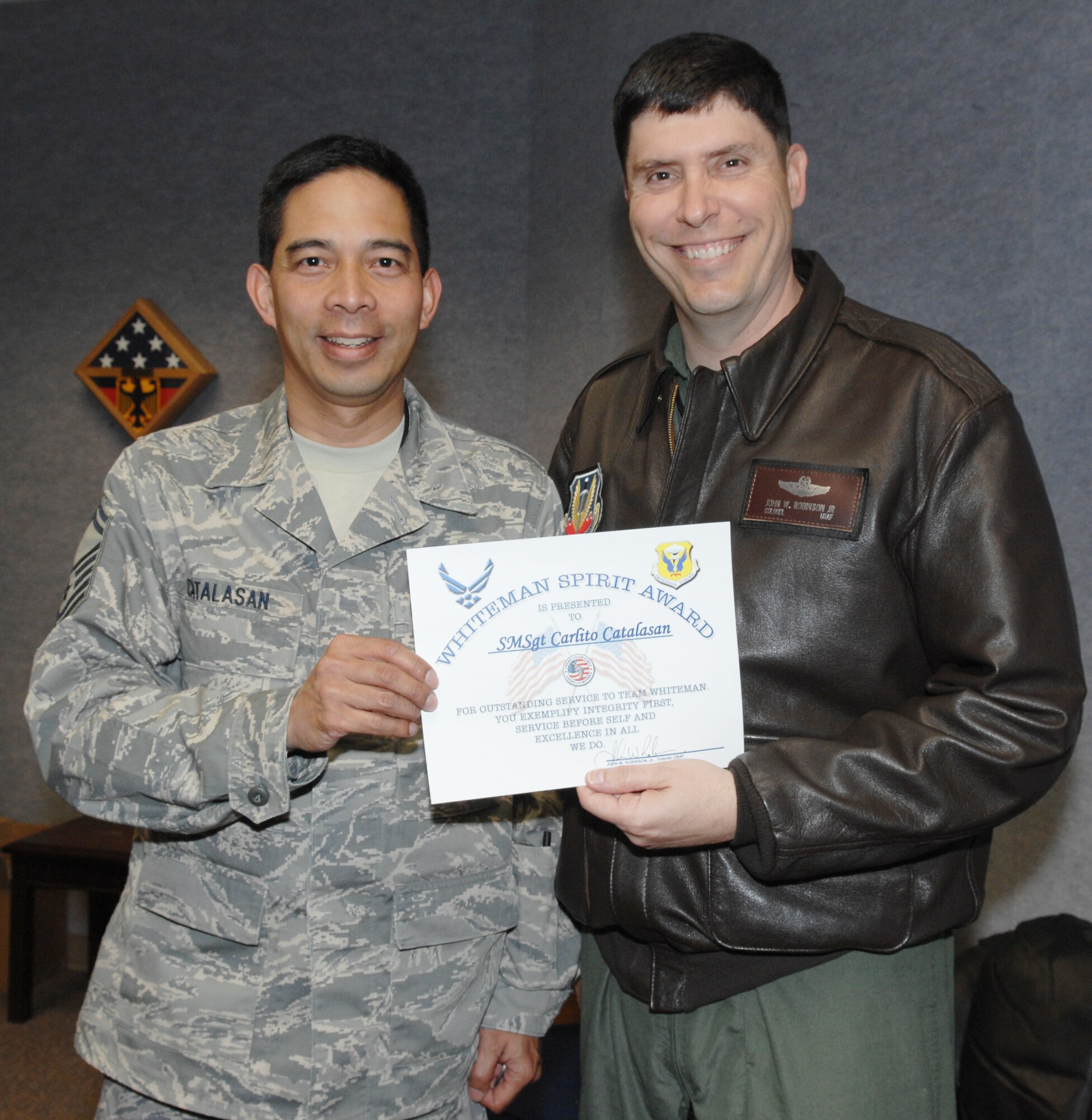 WHITEMAN AIR FORCE BASE, Mo - Senior Master Sgt. Carlito Catalasan, 509th Security Forces Squadron, receives the Whiteman Spirit Award from Col. John Robinson, 509th Bomb Wing vice commander April 28. Sergeant Catalasan was nominated for the award by Stacey Consley for his professionalism and leadership abilities. (U.S. Air Force photo/1st Lt. Candace Cutrufo)