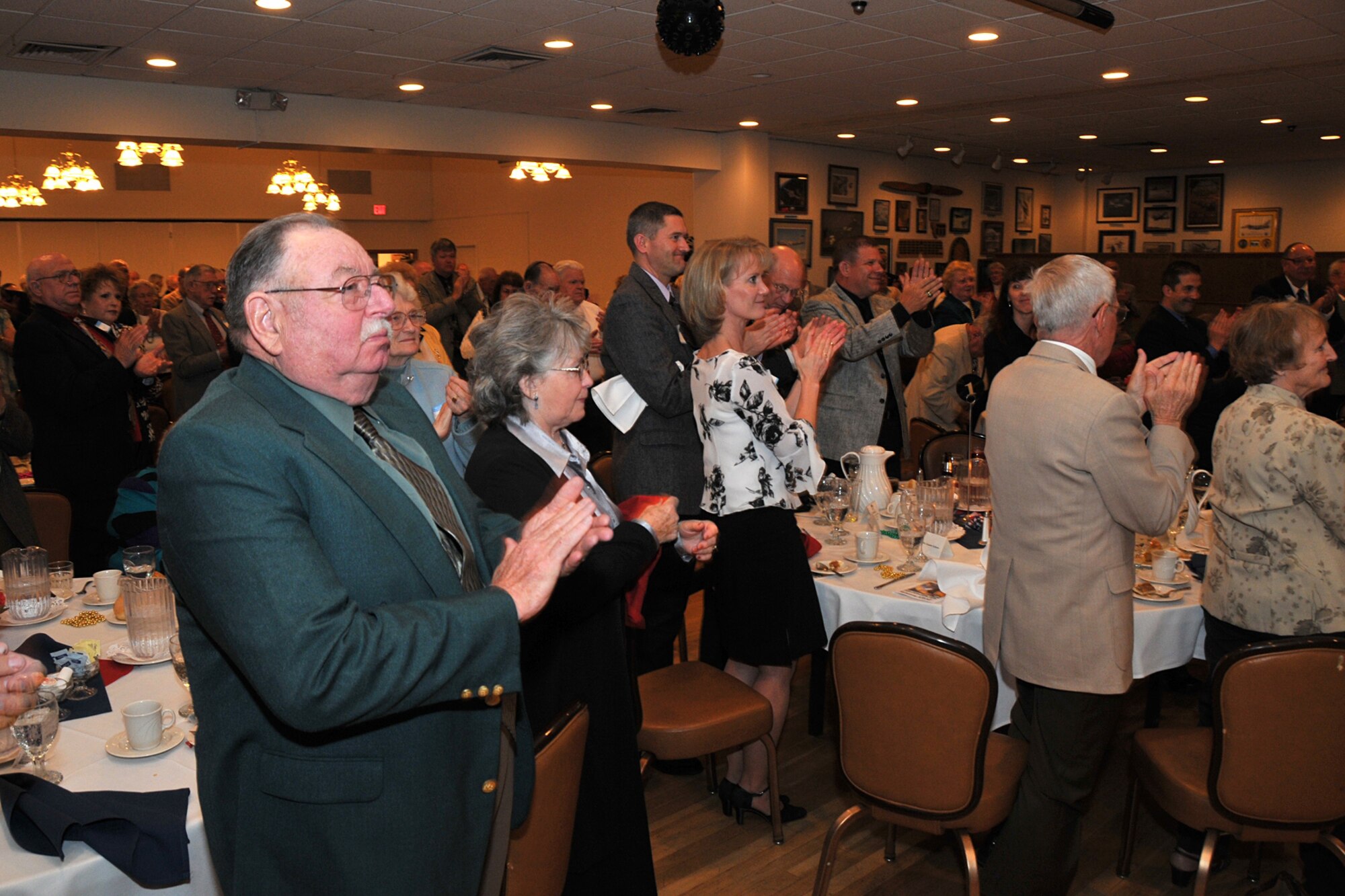 More than 160 retirees and guests stand and applaud following a performance by the Top of the Falls Chorus during intermission. The group performed eight numbers during the retiree appreciation dinner at the Grizzly Bend Club April 26. (U.S. Air Force photo/John Turner)