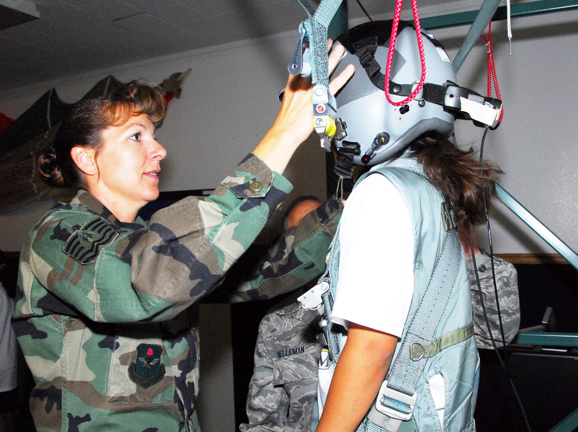 Tech. Sgt. Victoria Lacey shows a fourth-grade student the parachute simulator at the 162nd Operations Group. The tour, organized for the Wright Flight program, showed local school kids several examples of jobs found in the Air National Guard. (Air National Guard photo by Master Sgt. Dave Neve)