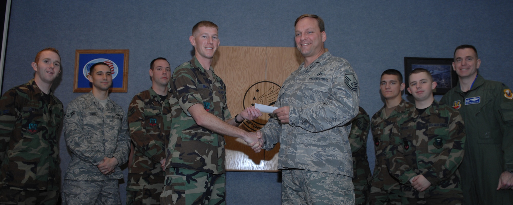 WHITEMAN AIR FORCE BASE, Mo. – Master Sgt. David Voke, 509th Operation Support Squadron, hands a check for $400 to Capt. Jason Mayne, Whiteman Air Force Assistance fund representative, as the members of the OSS that raised the $400 looked on April 28. Members of the 509th OSS put on a burger burn to raise money for AFAF. (U.S. Air Force photo/Airman 1st Class Stephen Linch)