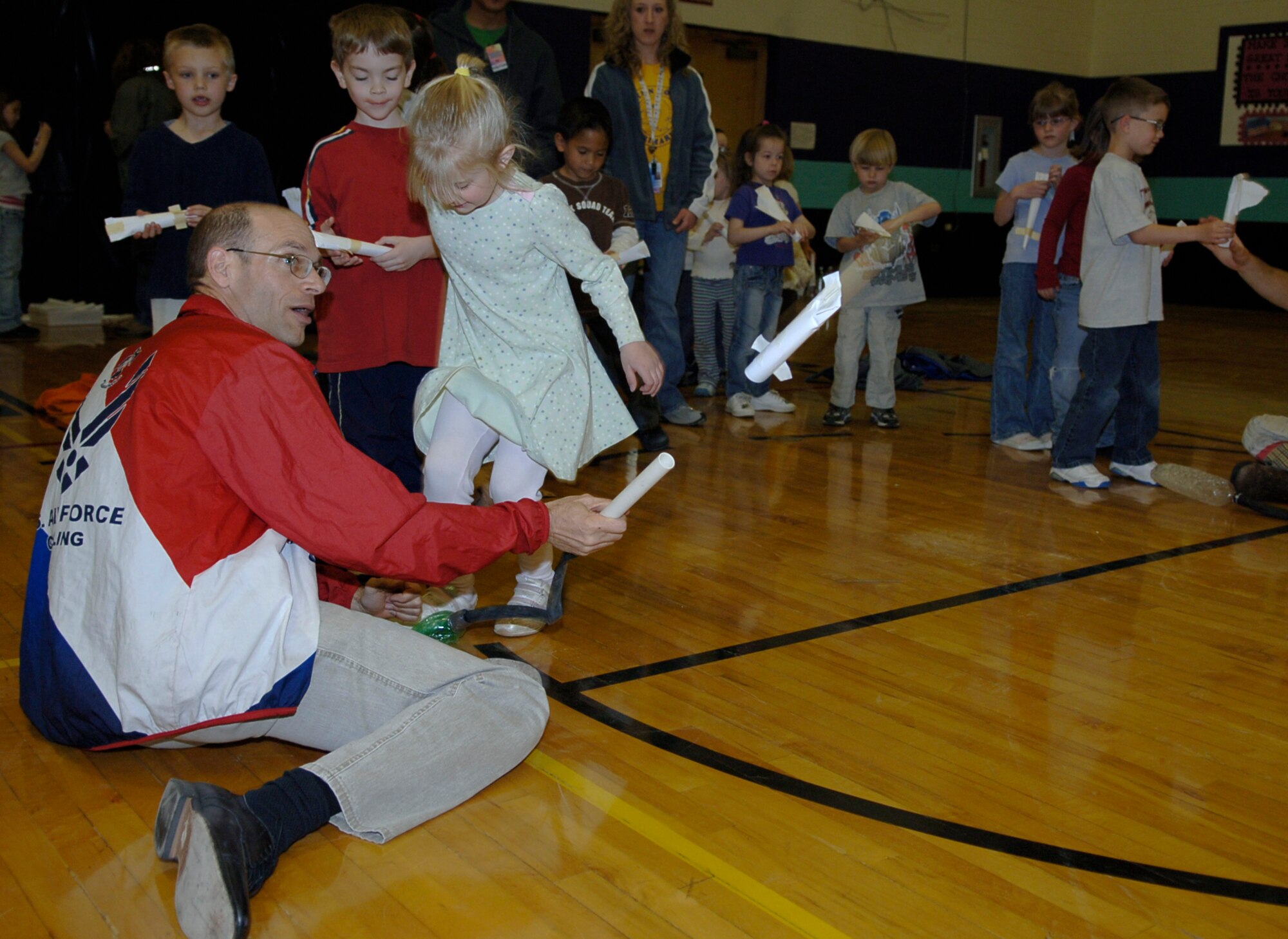 MOUNTAIN HOME AIR FORCE BASE, Idaho -- Left, Mark Werthmann, from the Discovery Center of Idaho, helps Tori Orcutt, a kindergartener from the Base Primary School, launch a rocket she made from paper, tape and paper clips during Science Day at Stephensen Middle School April 25. The Mountain Home Air Force Base Parent Teacher Partnership hosted Science Day to introduce students from kindergarten through fourth grade to the world of science. (U.S. Air Force photo/Airman 1st Class Samantha S. Crane)