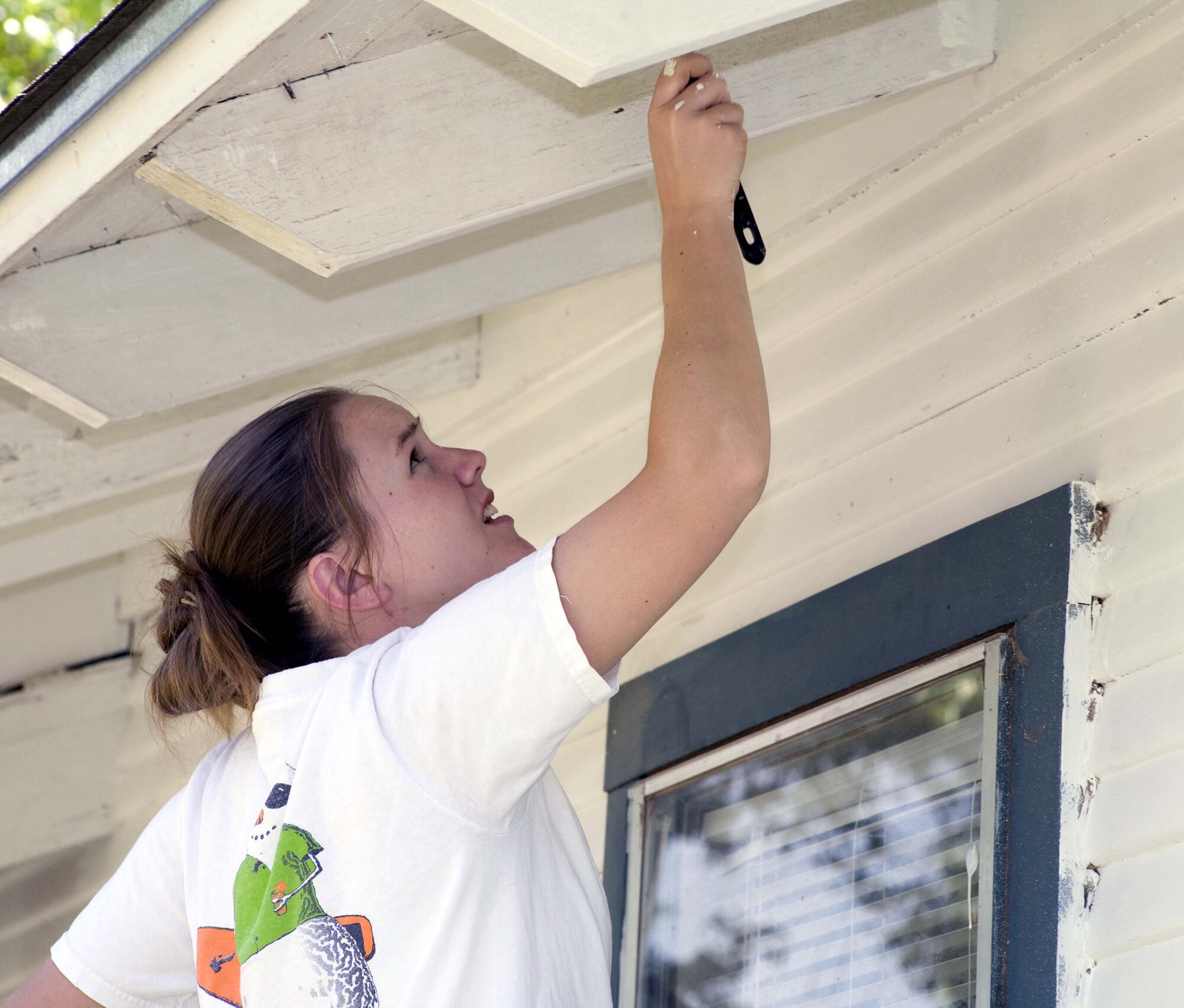 80th Flying Training Wing protocol officer Lt. Colleen Smalley paints the facia of a house April 26 as a volunteer for Christmas in Action, a nonprofit organization that helps low-income or disabled homeowners with house repairs. More than 100 volunteers from Sheppard spanned out throughout the greater Wichita Falls area to help with repairs to about 70 homes. (U.S. Air Force photo/Lt. Col. Ternell Washington)