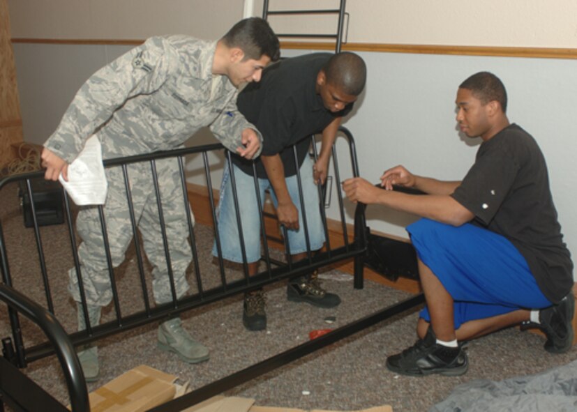 MINOT AIR FORCE BASE, N.D. -- Airman 1st Class Eric Estrada, 5th Medical Support Squadron, helps Airman 1st Class Jerome Louis and Airman 1st Class Victor Calcote, 742nd Missile Squadron put together a futon in the new Airmen's Center here April 14. The Airmen's Center includes a ping pong table, gaming conoles, big screen televisions and an array of other items. (U.S. Air Force photo by Airman 1st Class Sharida Bishop)