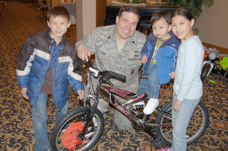 MINOT AIR FORCE BASE, N.D. -- The Wong children celebrate with Lt. Col. Joseph Ogea, 5th Force Support Squadron commander, after winning one of the bikes given away during the Month of the Military Child brunch at the Jimmy Doolittle Center on Minot Air Force Base April 27. Pictured are (left to right) Christian Wong, Camden Wong and Lauren Wong. The children's parents are Joanne and Maj. Grand Wong, 5th Medical Operations Squadron. Other winners of bikes or age-appropriate prizes were: Emily Jones, LaRae Ordaz, Jostacia Thomas, Paul Murray, Damian Dawkins Jr., Bailey Young and Emily and Johnathan Moehle. (Courtesy photo)