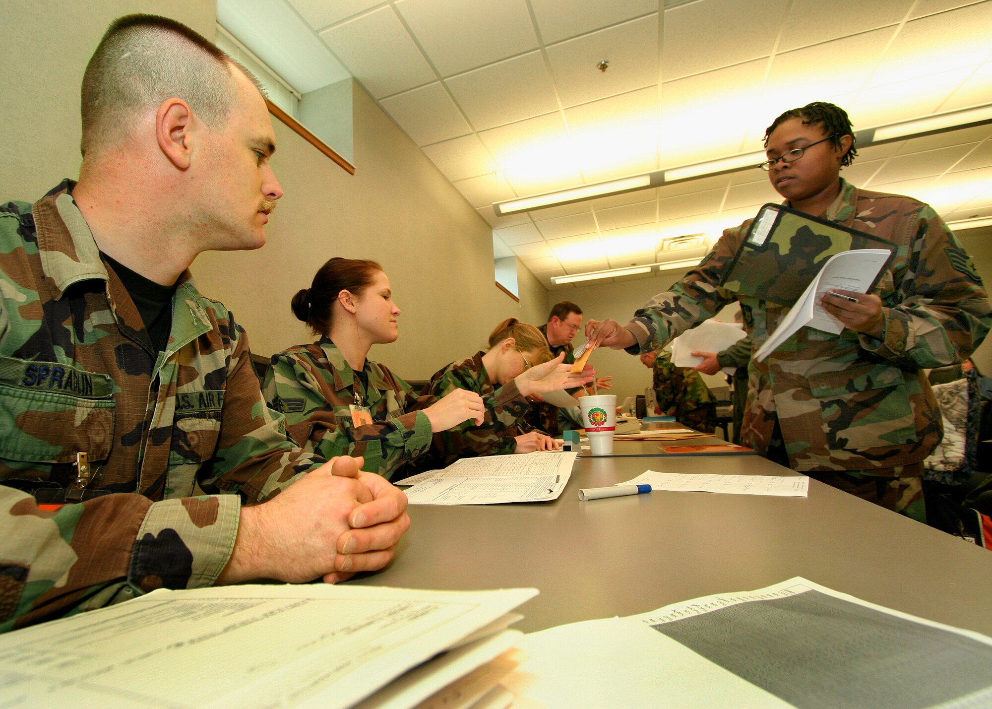 GRISSOM AIR RESERVE BASE, Ind., -- Staff Sgt. Damon Spradlin and Senior Airman Erica Suchovsky, both from 434th Aerospace Medicine Squadron, review the dog tags of Staff Sgt. Charlene Howard, computer operations specialist with the 434th Communications Squadron, as she makes her way through the mobility processing line.  (U.S. Air Force Photo/Tech. Sgt. Patrick M. Kuminecz)