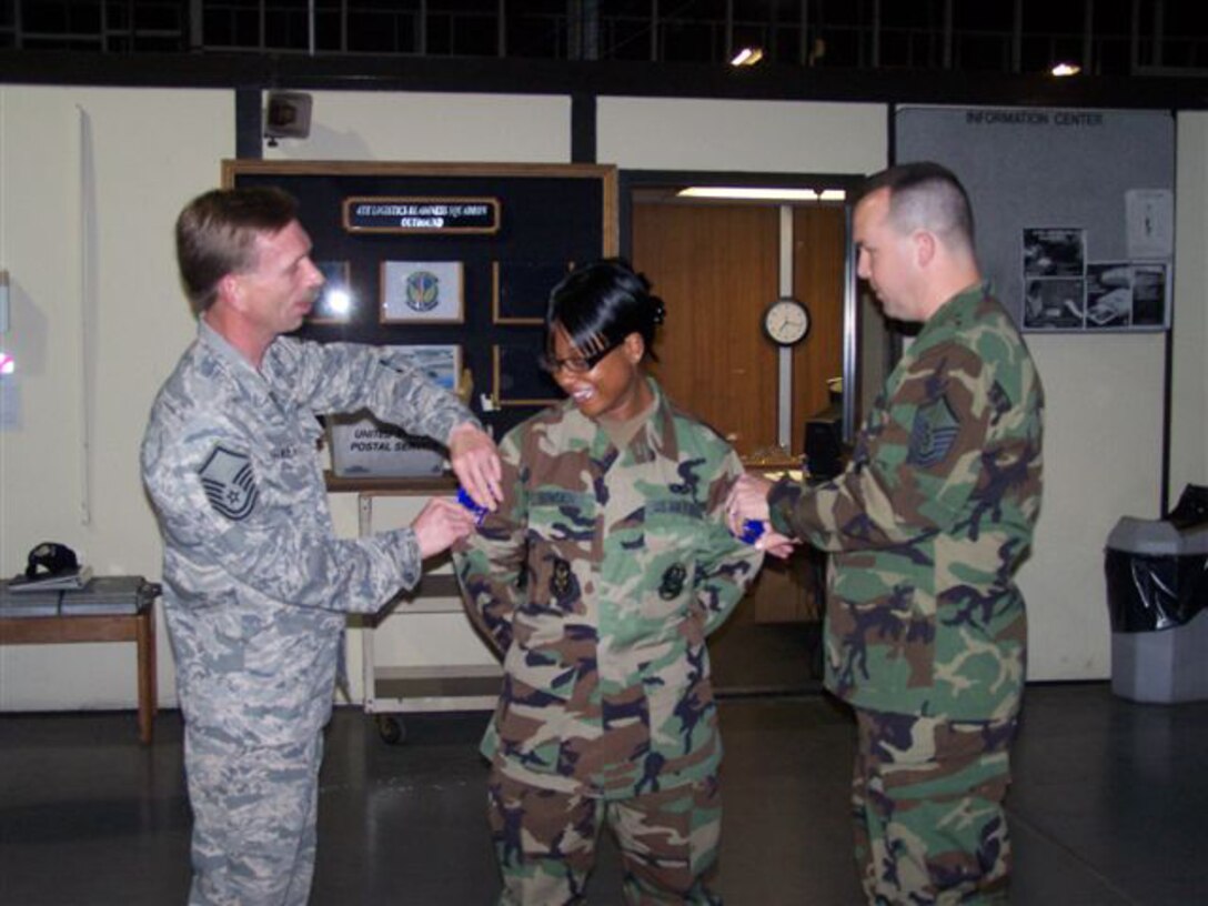 SEYMOUR JOHNSON AIR FORCE BASE, N.C. -- Tech. Sgt. Shinnita Bowden (center) is promoted to her new rank during the April unit training assembly. Master Sgt. Chris Burket (left) and Master Sgt. Bruce Langston pin on her new stripes. Sgt. Bowden is a supply management journeyman with the 916th Logistics Readiness Squadron.