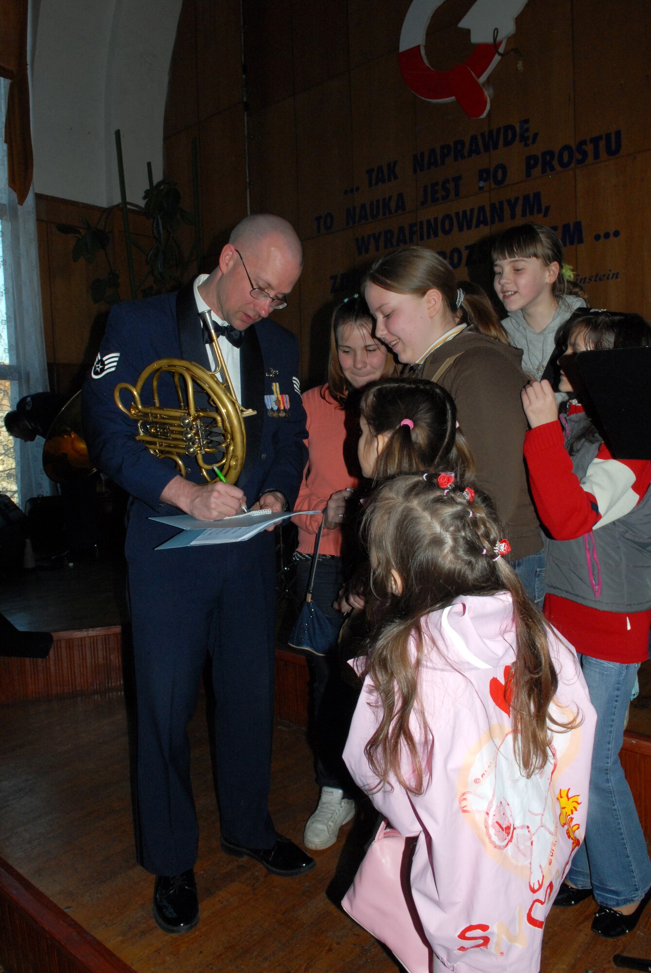 Staff Sgt. Clay Toms, United States Air Forces in Europe's Band Five Star Brass, signs autographs for the children at a concert in Kolobrzeg, Poland, April 21. Winds Aloft and the Five Star Brass performed six concerts during their tour in Poland. (U.S. Air Force Photo by Airman 1st Class Ruth Holcomb) (Released)