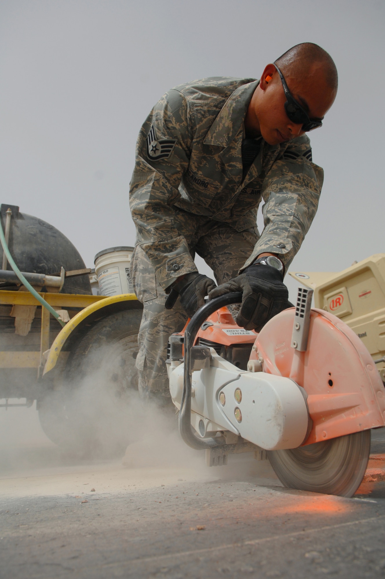 BALAD AIR BASE, Iraq -- Staff Sgt. Edward Nicandro, 332nd Expeditionary Civil Engineer Squadron spall unit member, cuts out a jagged section of the runway that was dislodged by an aircraft here, April 28. The sections of the runway that crack or split are called spalls, these spalls cause foreign object debris that could potentially disable aircraft engines. Sergeant Nicandro is deployed from Peterson Air Force Base, Colo. (U.S. Air Force photo/ Senior Airman Julianne Showalter)