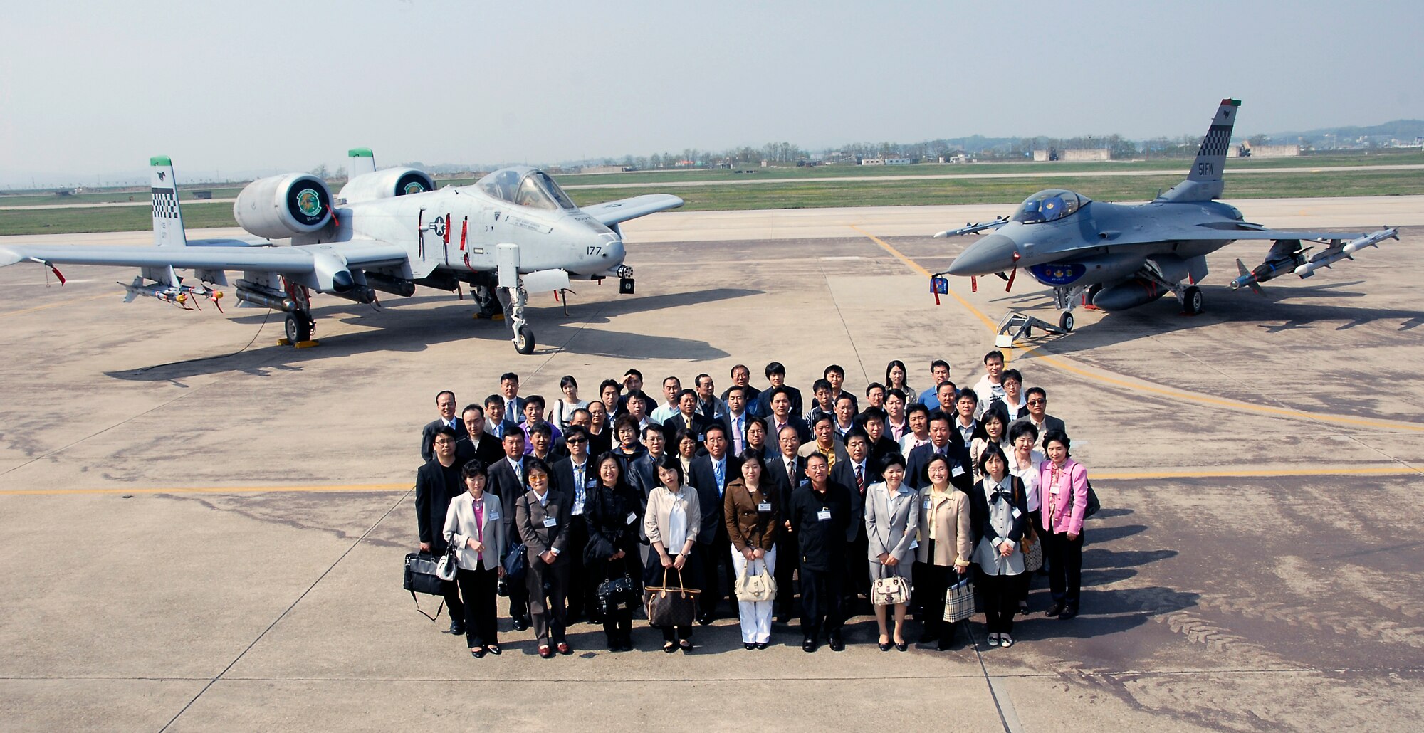 OSAN AIR BASE, Republic of Korea – Korean Young Leaders take a moment to pose with A-10 (left) and F-16 (right) on the flightline at Osan AB during their orientation of air and space power used to defend and protect the Republic of Korea. During their time at Osan AB, delegates participated in a number of leadership briefings and tours with Airmen.  These type visits are a testament to the ROK-US alliance.  For over the last half century, the ROK-US alliance remains resilient in the face of adversity and adaptive to the constantly changing situations in the region.  (U.S. Air Force photo/Staff Sgt. Scottie McCord)