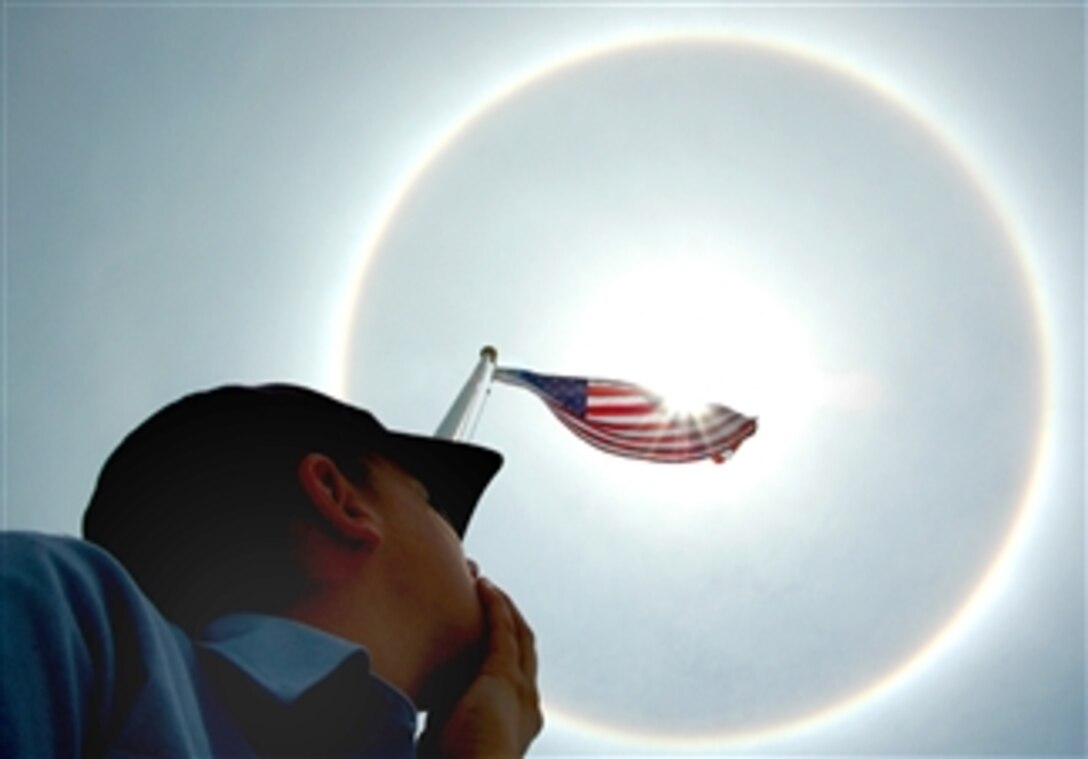 A U.S. Navy sailor stationed at Naval Air Station Key West spots a rare rainbow halo in the skies over the air station, Key West, Fla., April 29, 2008. The halo, which typically indicates rain, is a ring of colored or white light that encircles the sun when seen through a cloud of ice crystals. 