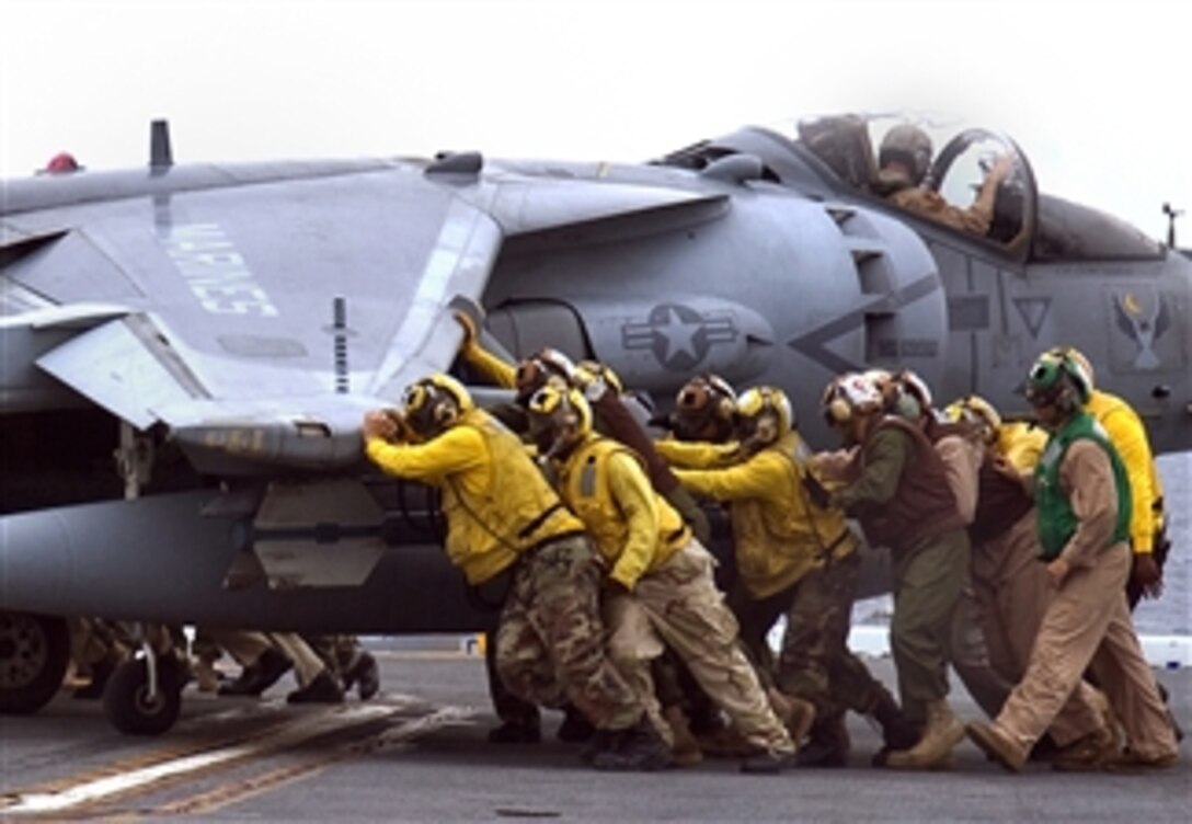 U.S. Navy sailors from the amphibious assault ship USS Essex push an AV-8B Harrier, assigned to the VMA-513 "Nightmares," onto the ship's aircraft elevator while at sea, April 29, 2008. 