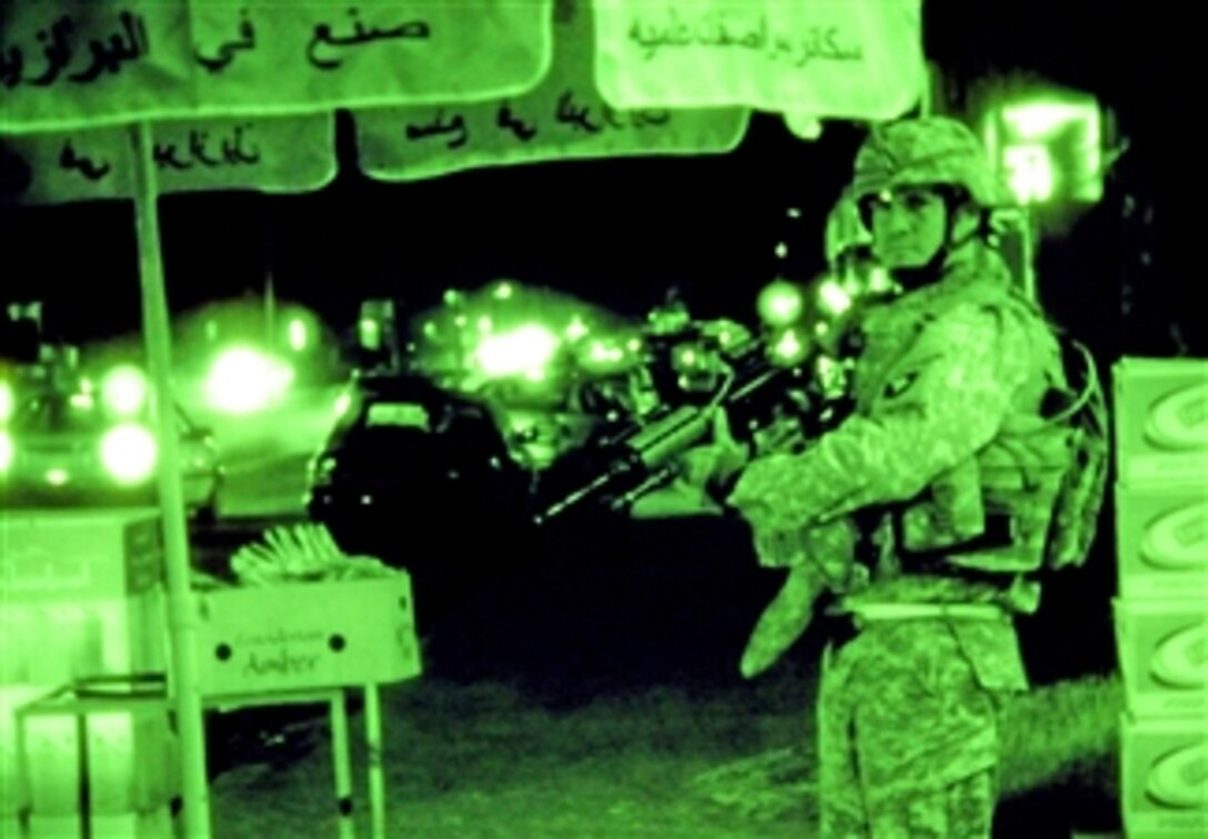Seen through a night vision device, a  U.S. soldier keeps an eye on a busy neighborhood in Tikrit, Iraq, April 24, 2008, where local citizens are shifting their concerns from security to economics. The soldier is assigned to the 101st Airborne Division's 1st Brigade Combat Team.