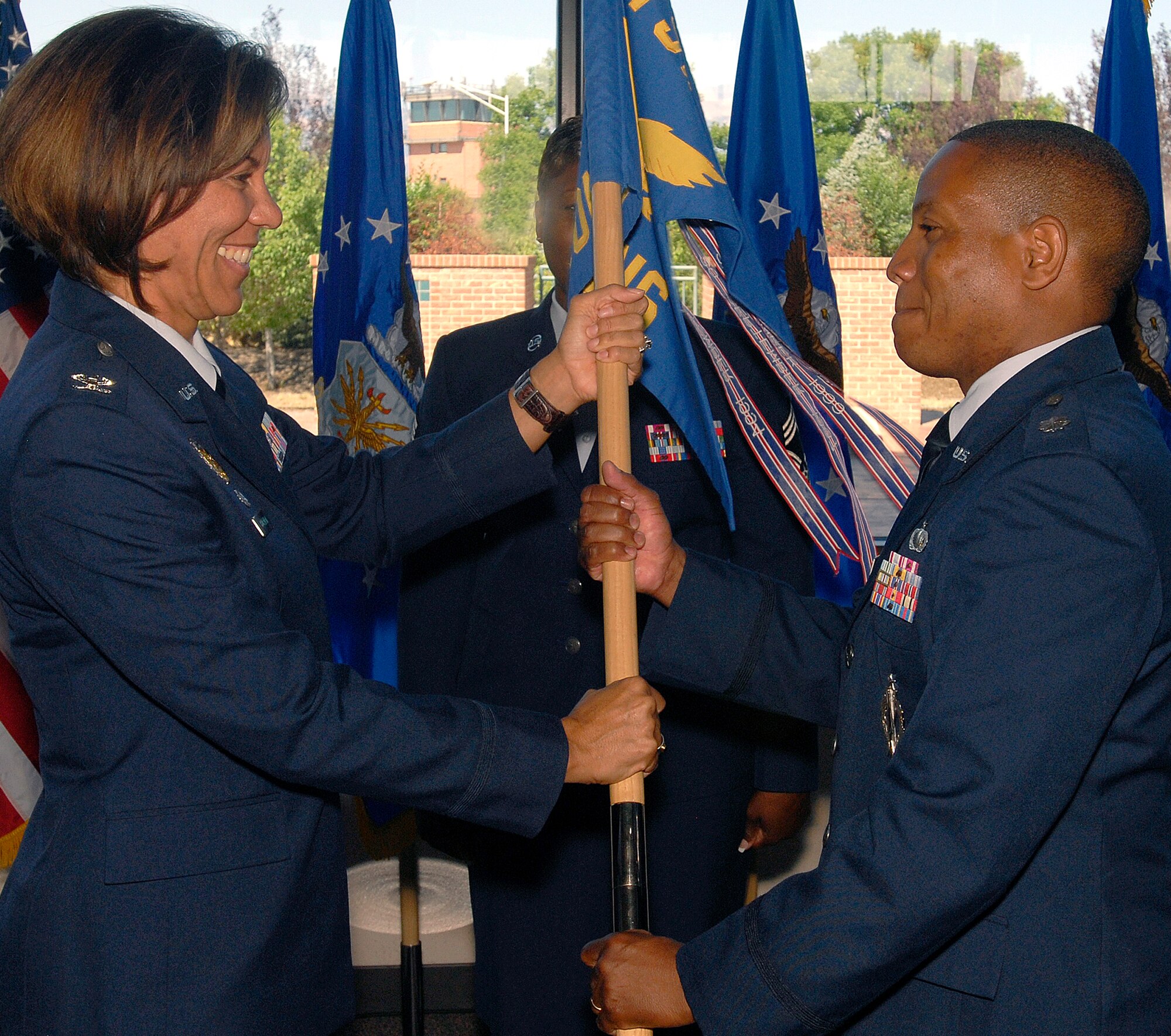 Lt. Col. Curtis Jordan (right) assumes command of the 21st Contracting Squadron  from Lt. Col. Robert Widmann (not pictured) July 31 in a ceremony officiated by Col. Emily Buckman (left), 21st Mission Support Group commander at Peterson Air Force Base, Colo. Colonel Jordan comes from Allied Joint Force Command Brunssum, The Netherlands (NATO), where he was the J7 executive officer. The outgoing commander, Colonel Widmann, remains at Peterson, where he assumes the position of the 21t Space Wing Inspector General. (U.S. Air Force photo/Craig Denton)