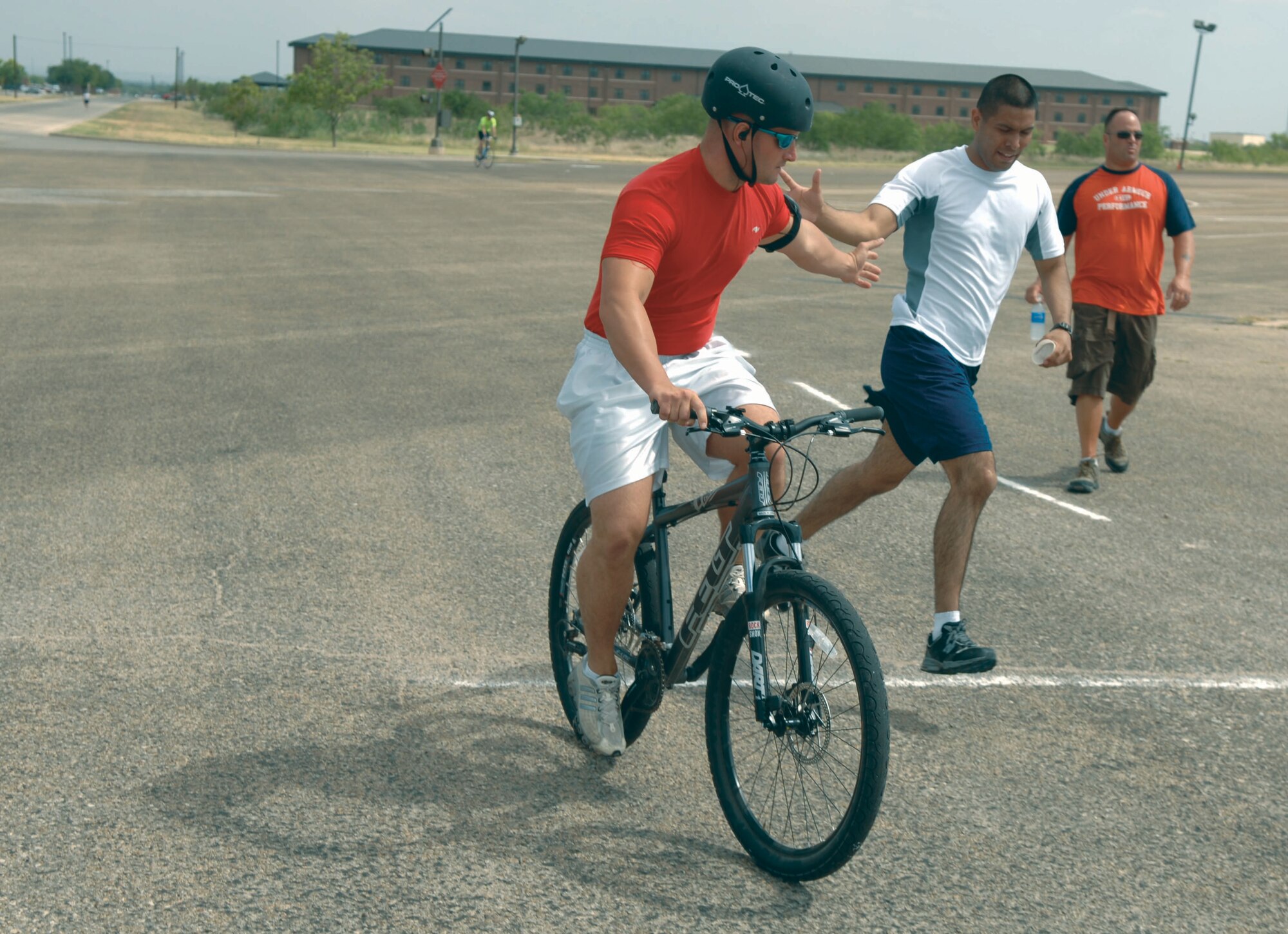 Jesus Villafn (center) tags teammate Ben Cully (on bike) during the base Triathlon Saturday at the corner of
Kickapoo and Apache Trails. Cully and Villafn, along with teammate Ken Cawthon, beat nine other teams in the
relay category. For the full story, see page 7. (U.S. Air Force photo by Staff Sgt. John Barton)